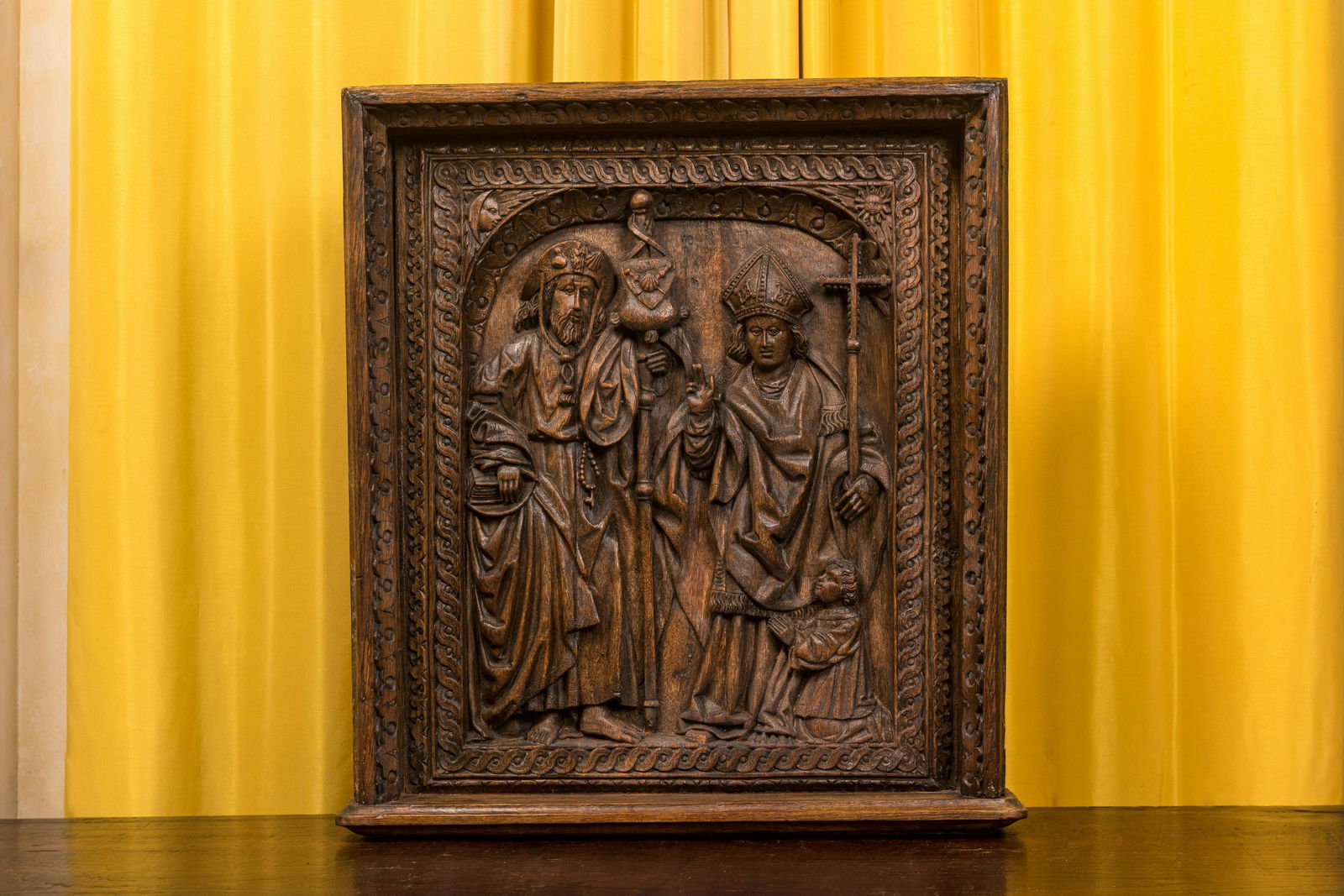 A carved oak panel depicting Saint James with a bishop, The Low Countries, late 15th C. (1 of 3)