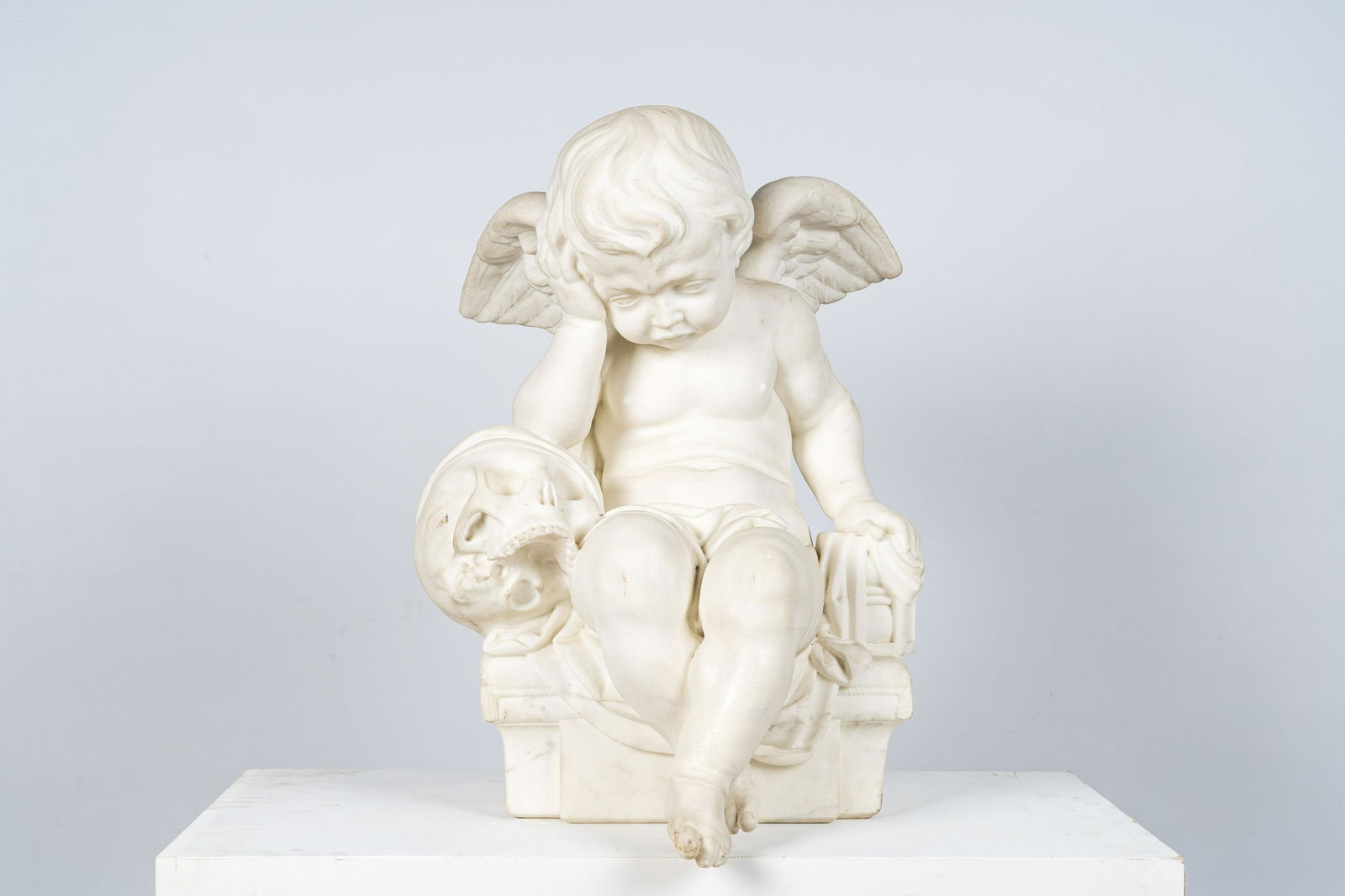 A white marble 'grieving putto' sculpture, 20th C. (1 of 4)