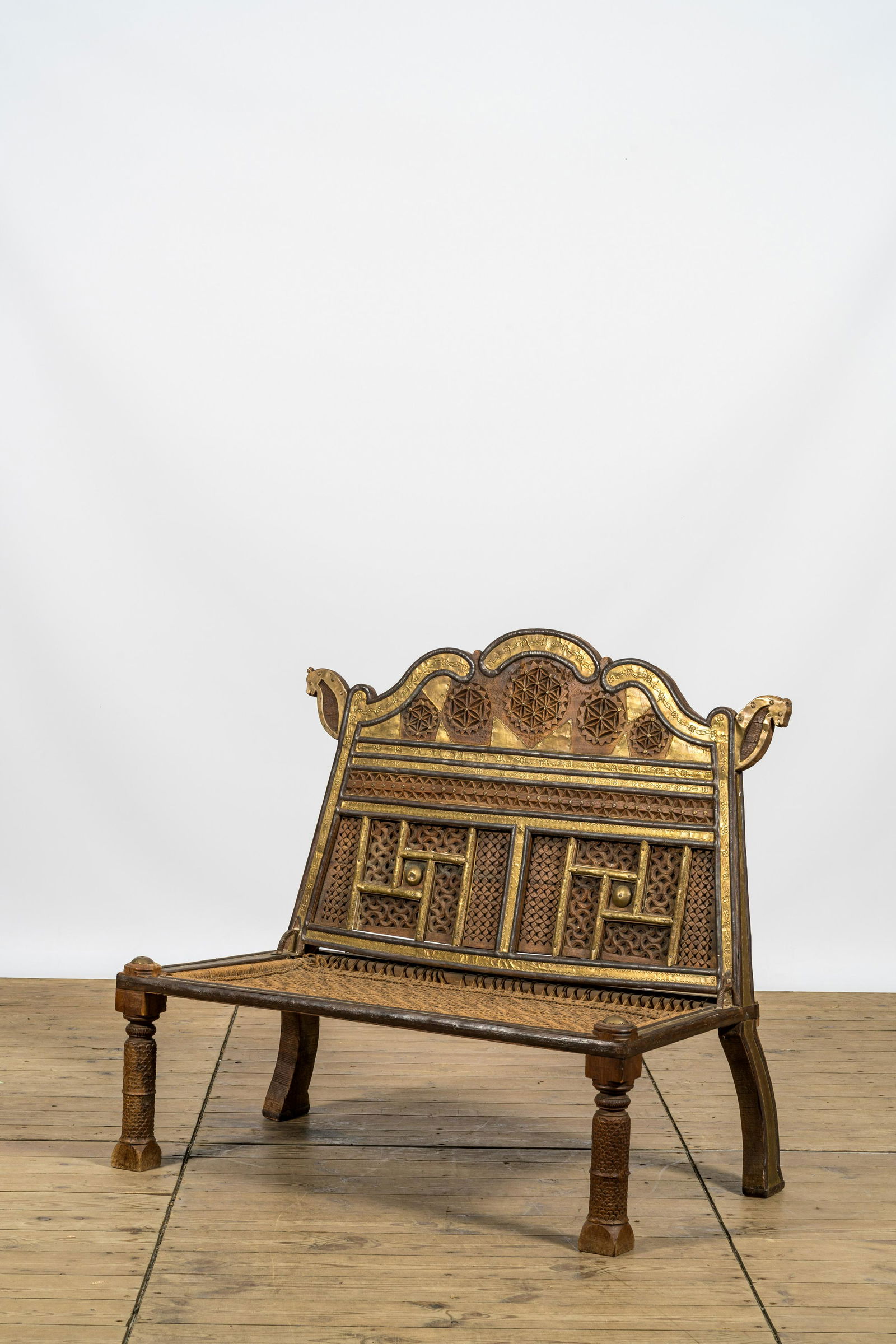 A colonial-inspired brass mounted wooden bench, 20th C. (1 of 5)
