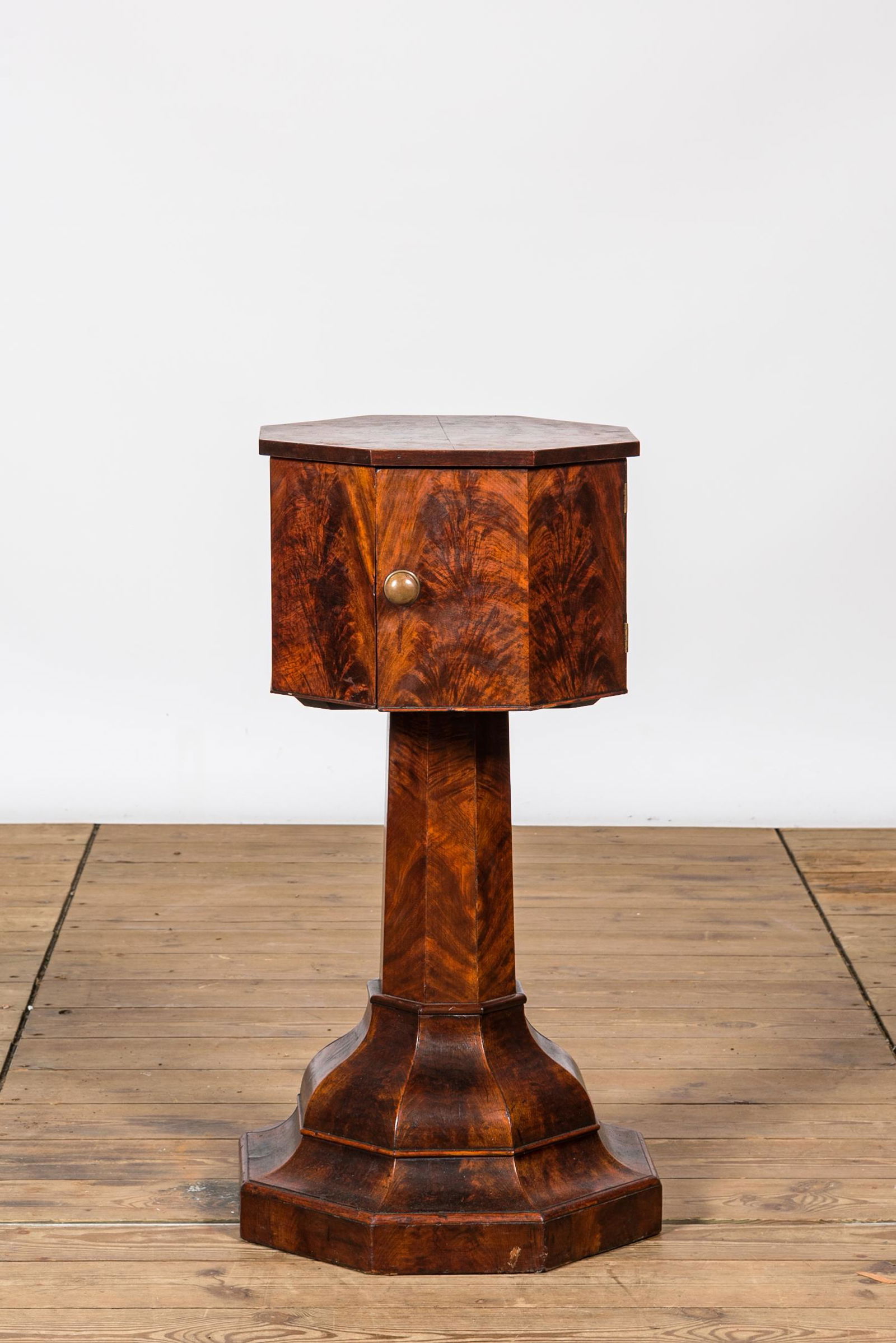 An octagonal mahogany one-door cabinet table, 19th C. (1 of 2)