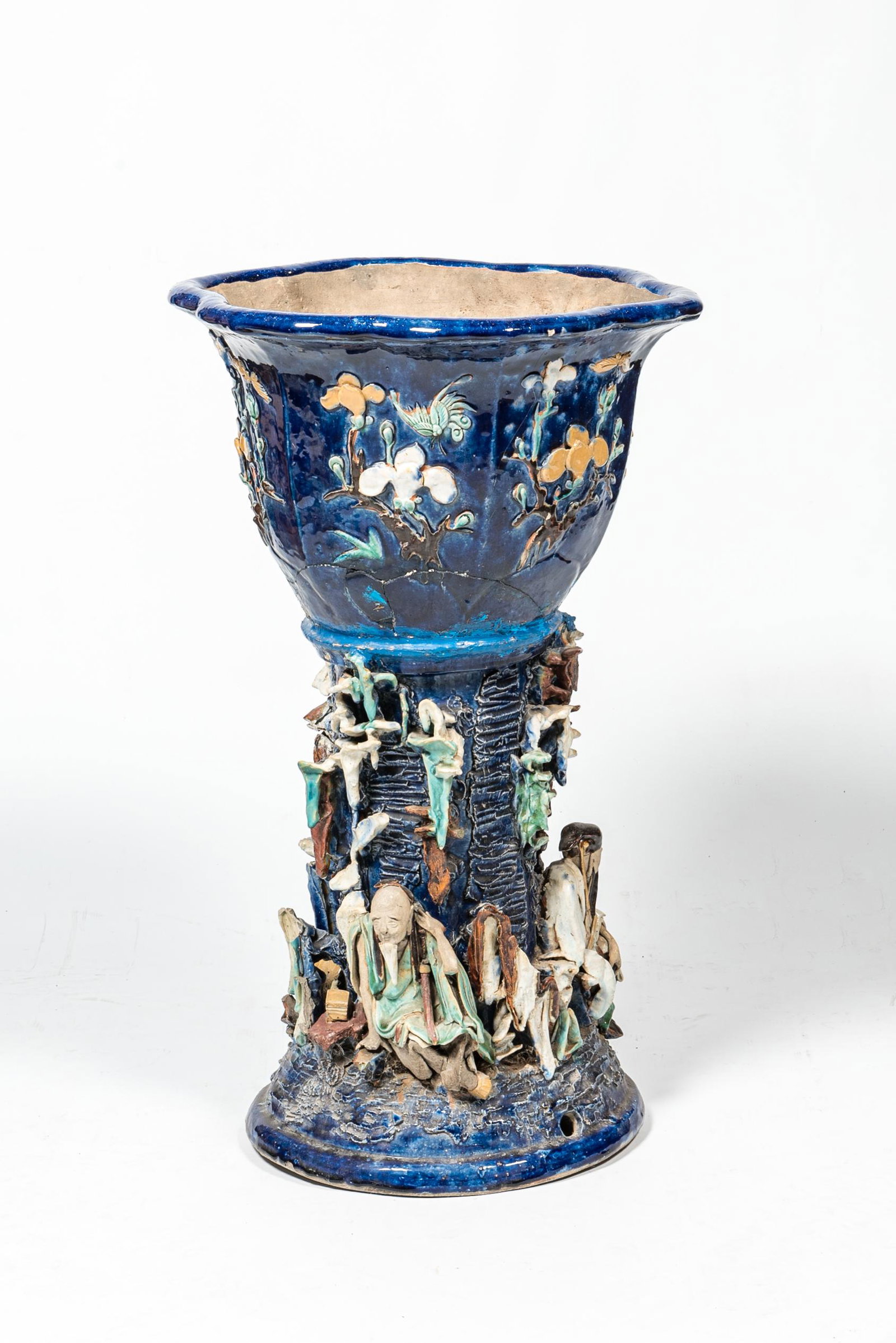 A Chinese polychrome Shiwan pottery jardiniere on stand with applied design of scholars, 19th C.: Full title: A Chinese polychrome Shiwan pottery jardiniere on stand with applied design of scholars, 19th C. Description: H 79 cm About this sale: Paul De Grande is one of the major dealers of antique