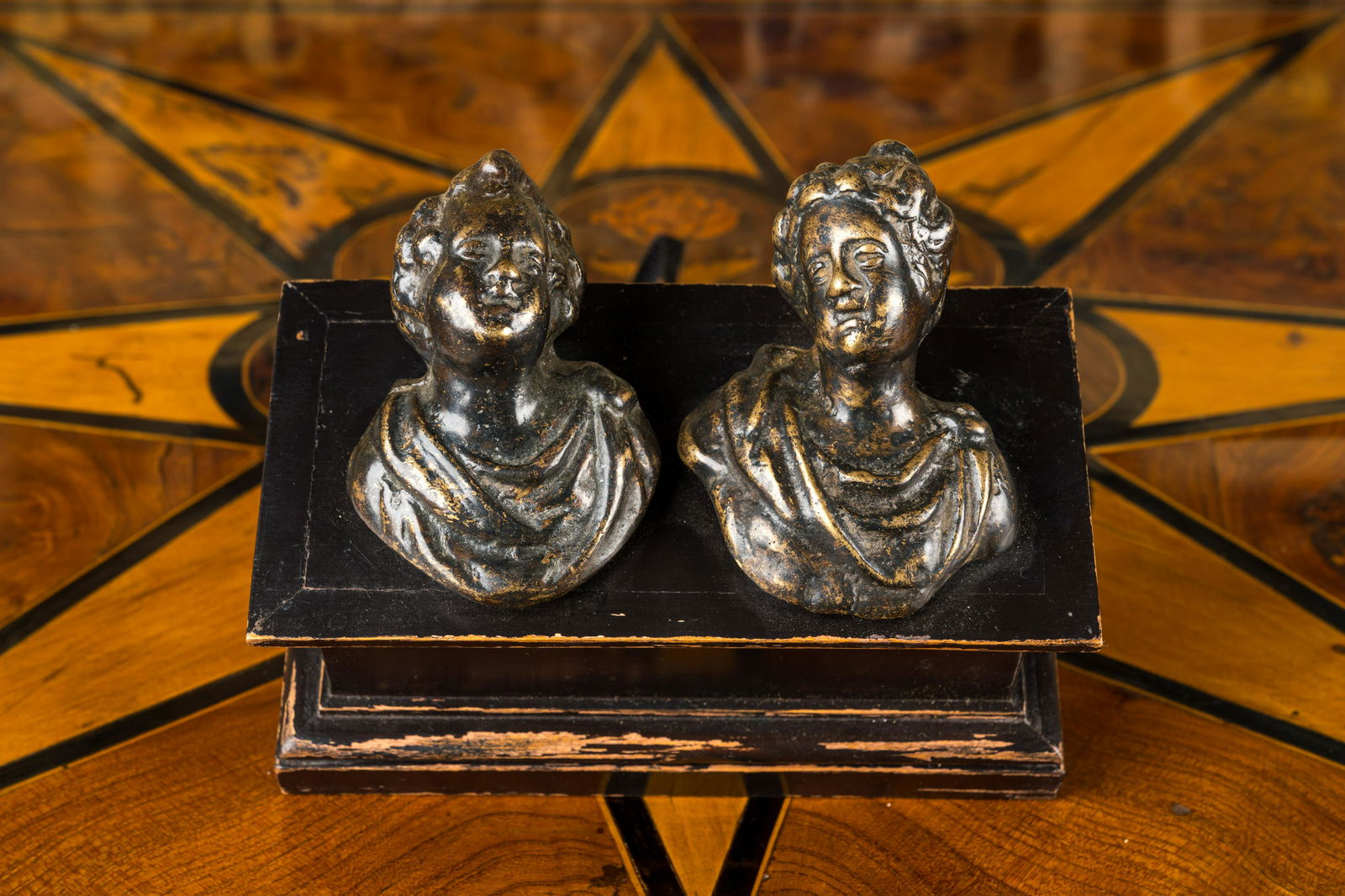 A pair of Italian patinated bronze miniature busts mounted on a later ebonised wooden stand, 17th C. (1 of 2)