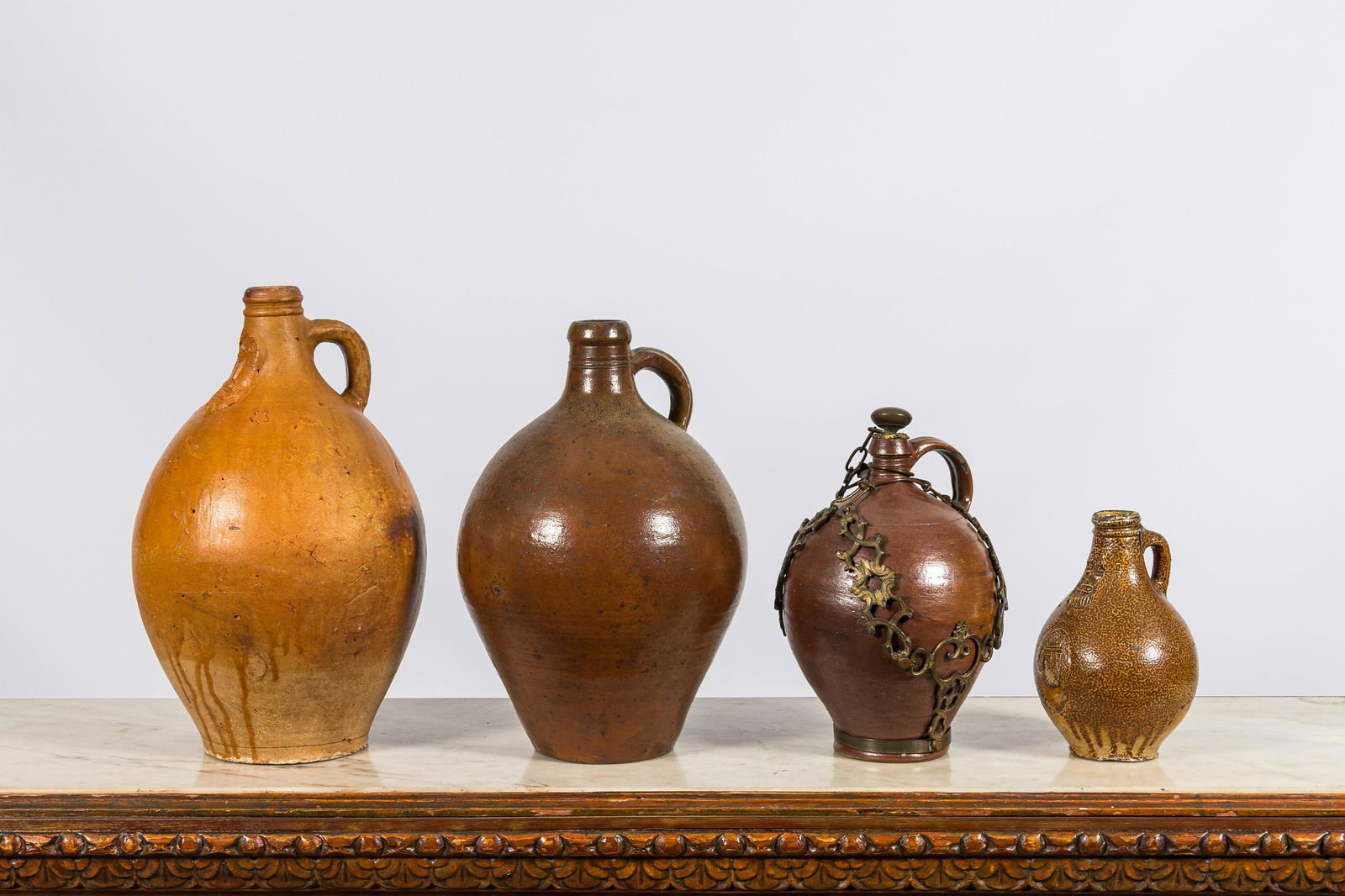 Four various stoneware jugs, incl. two bellarmine jugs and one with a gilt bronze chain mount, (1 of 4)
