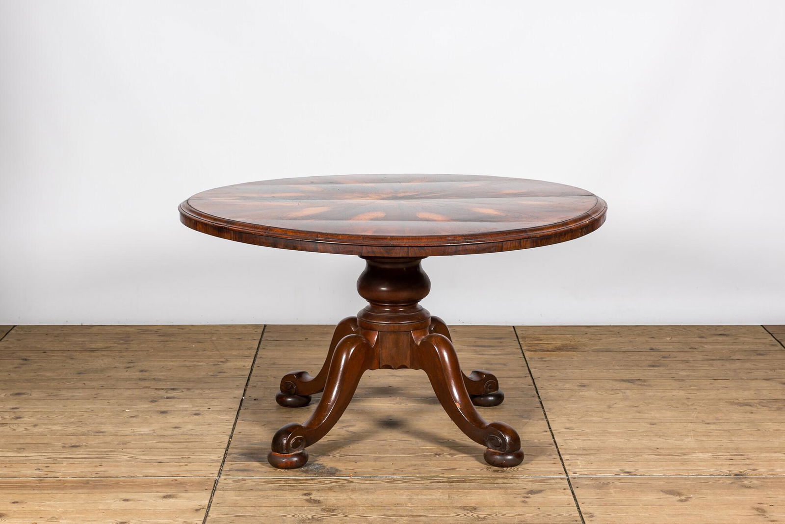 A round rosewood table on a mahogany base, 19/20th C. (1 of 2)