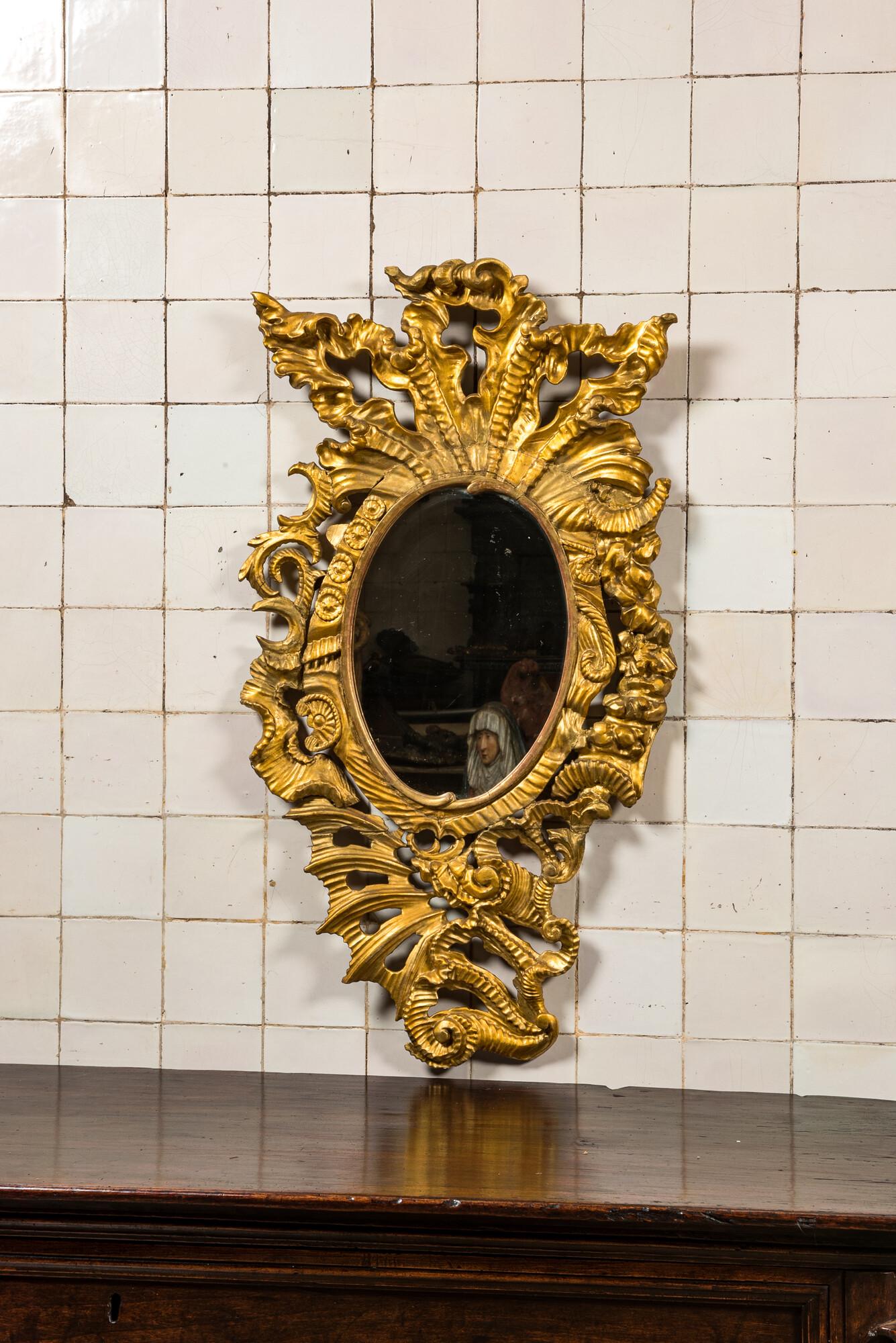 A richly carved gilt wooden Rococo mirror, 18th C. (1 of 2)