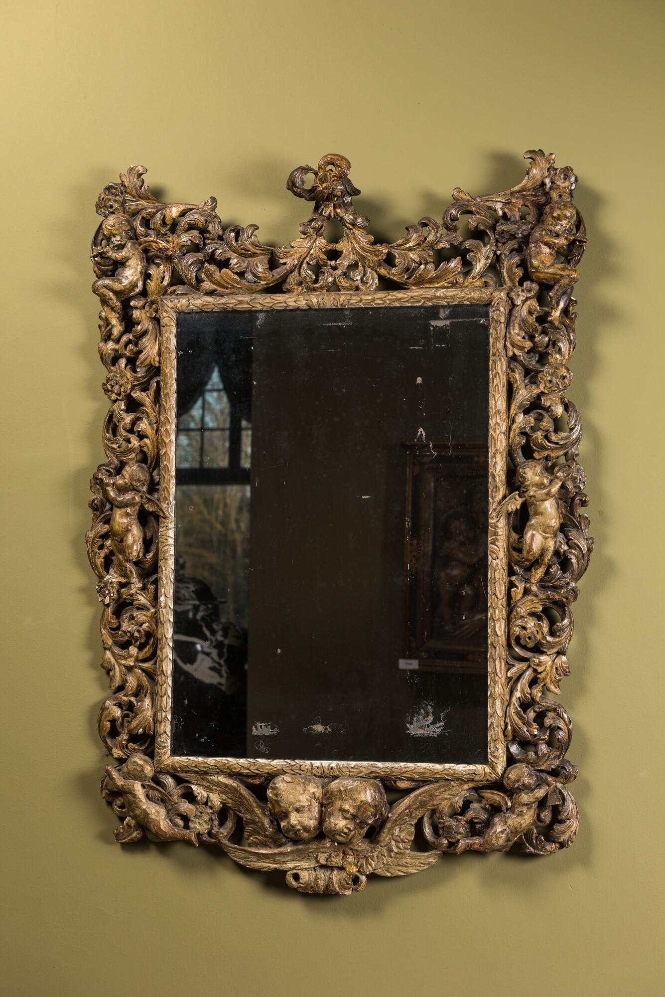 A finely carved polychromed wooden mirror with putti, Italy, 17th C. (1 of 3)