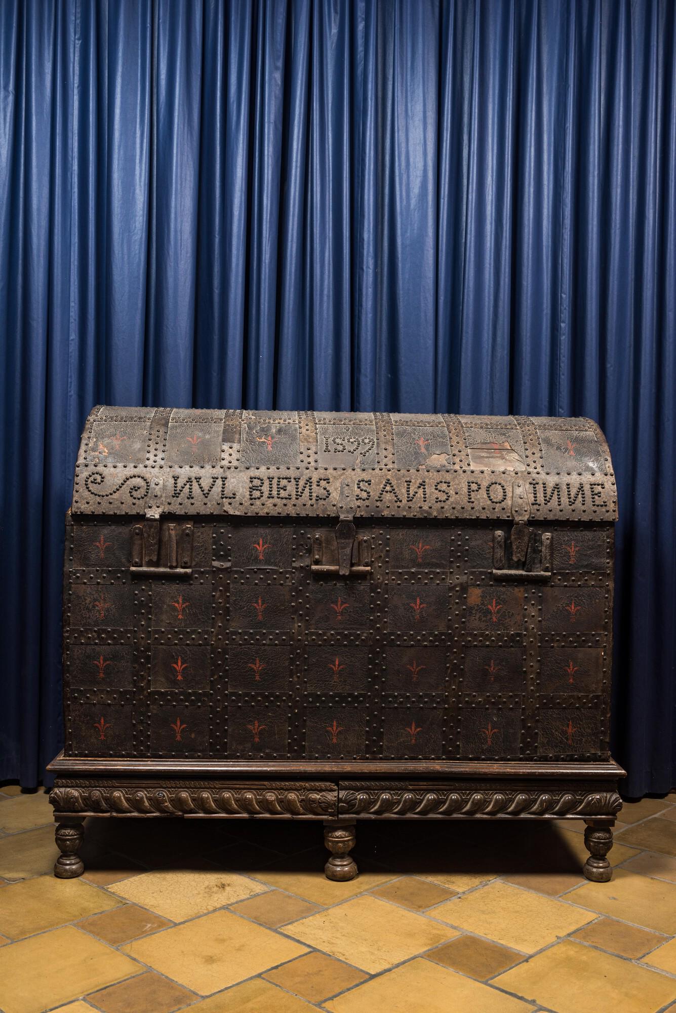 A large French wooden 'bahut' trunk with leather upholstery and wrought iron fittings on a wooden (1 of 3)