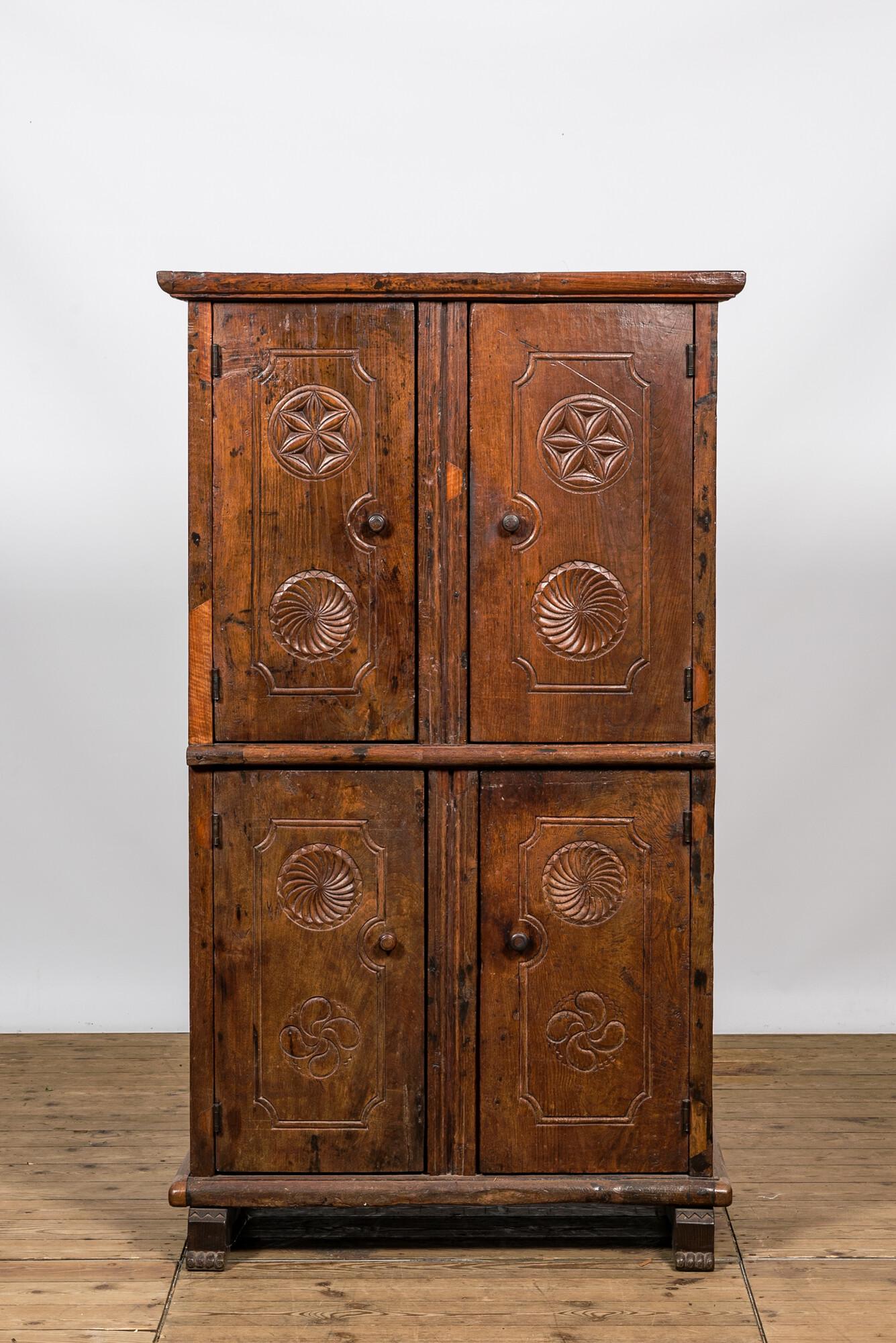 A wooden four-door cupboard with geometrical roundels, Southern Europe, 18/19th C. (1 of 3)