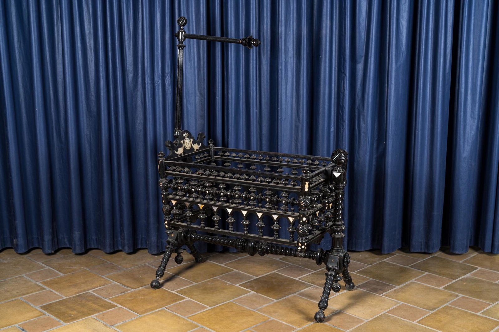 An attractive ebony-inlaid ebonised wooden cradle, 19th C. (1 of 5)