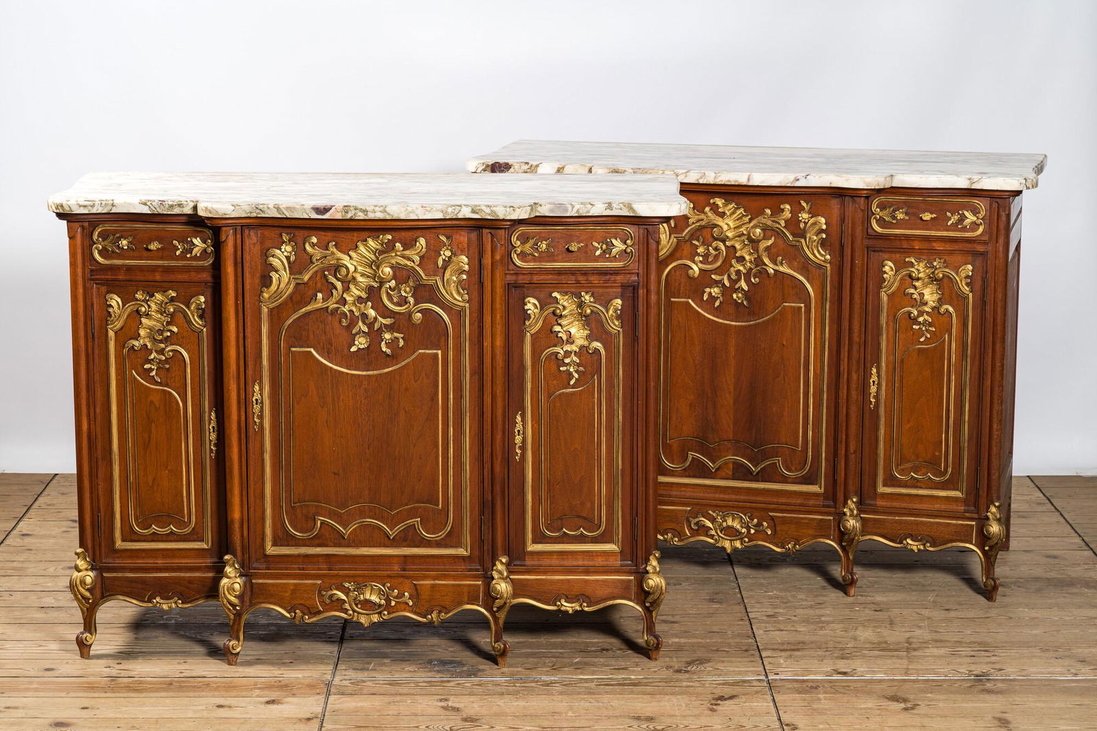 A pair of marble-topped partly gilded wooden side cabinets, 19/20th C. (1 of 7)