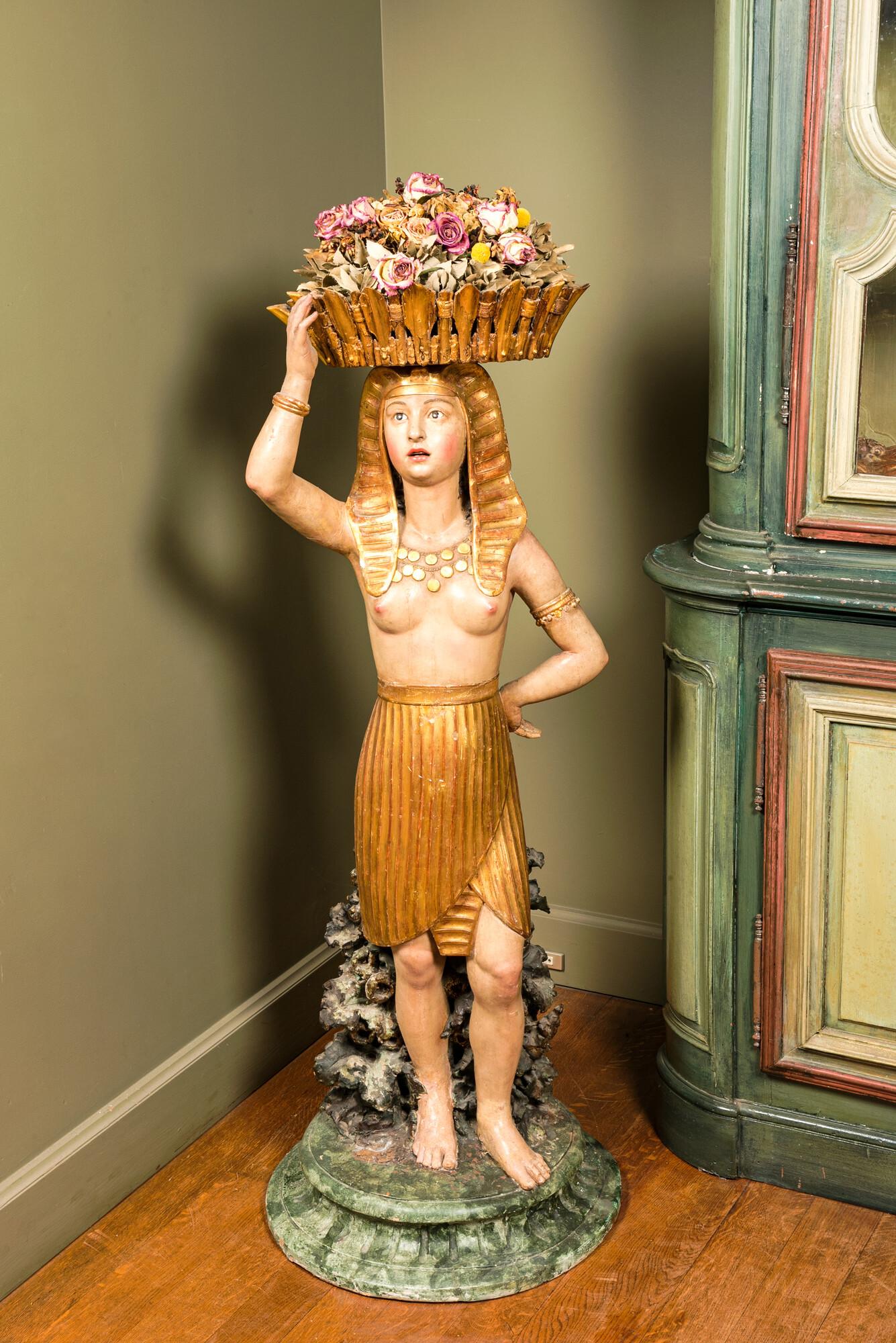 A polychrome terracotta 'Egyptomania' sculpture of an Egyptian lady with a flower basket, illegibly (1 of 4)