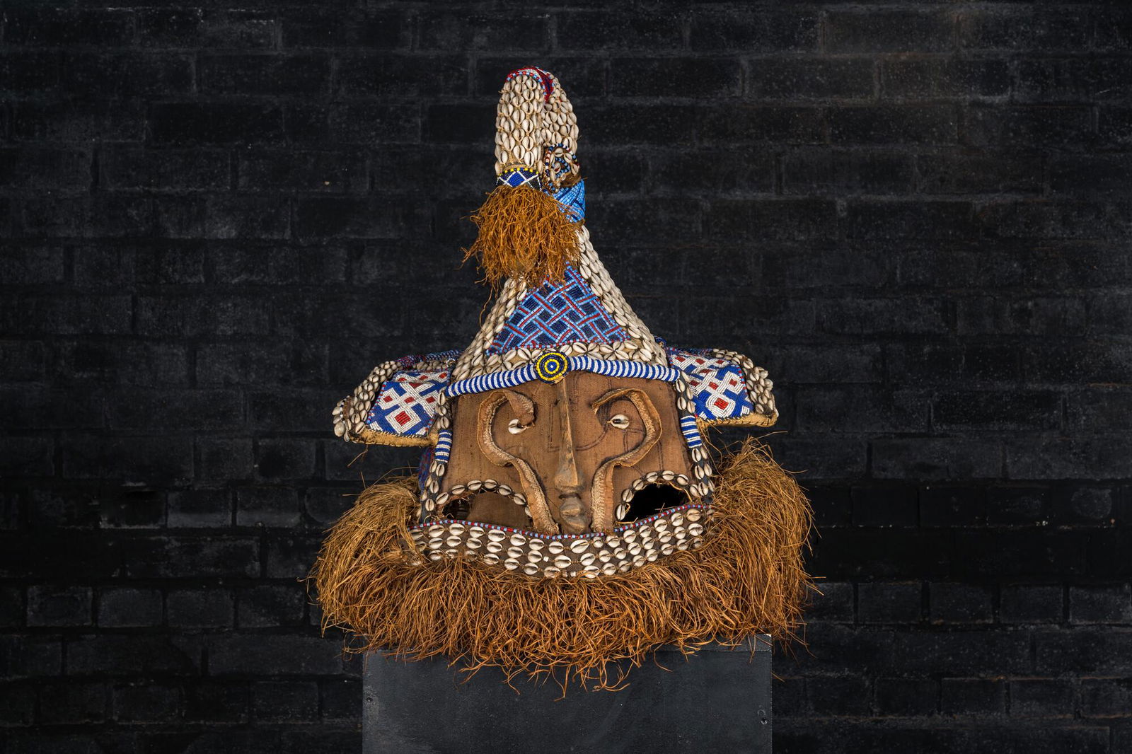 A Kuba helmet mask (mukenga) with cowrie shells, Congo, 20th C. (1 of 4)