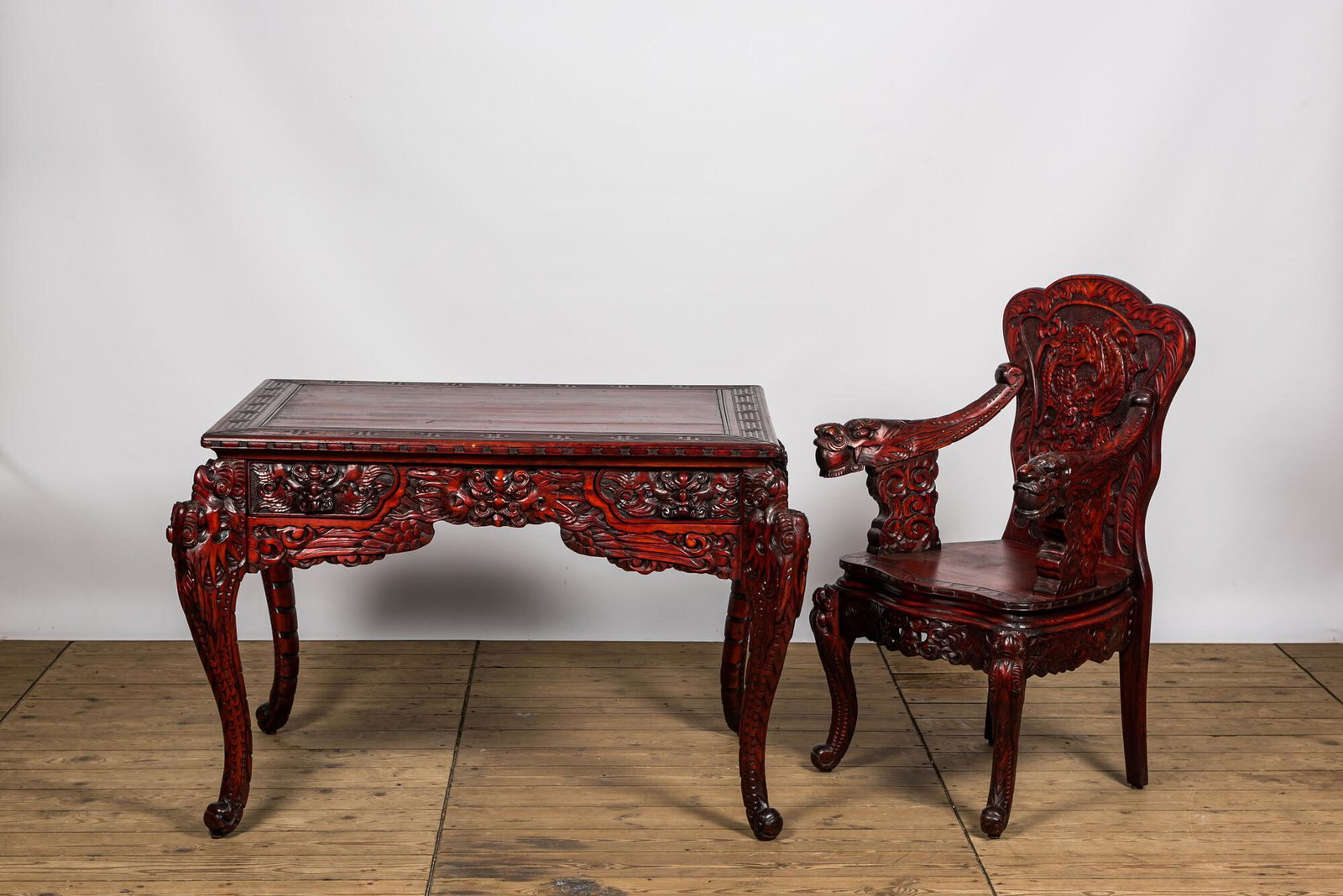 A finely carved Japanese red patinated wooden desk with armchair, 20th C. (1 of 2)
