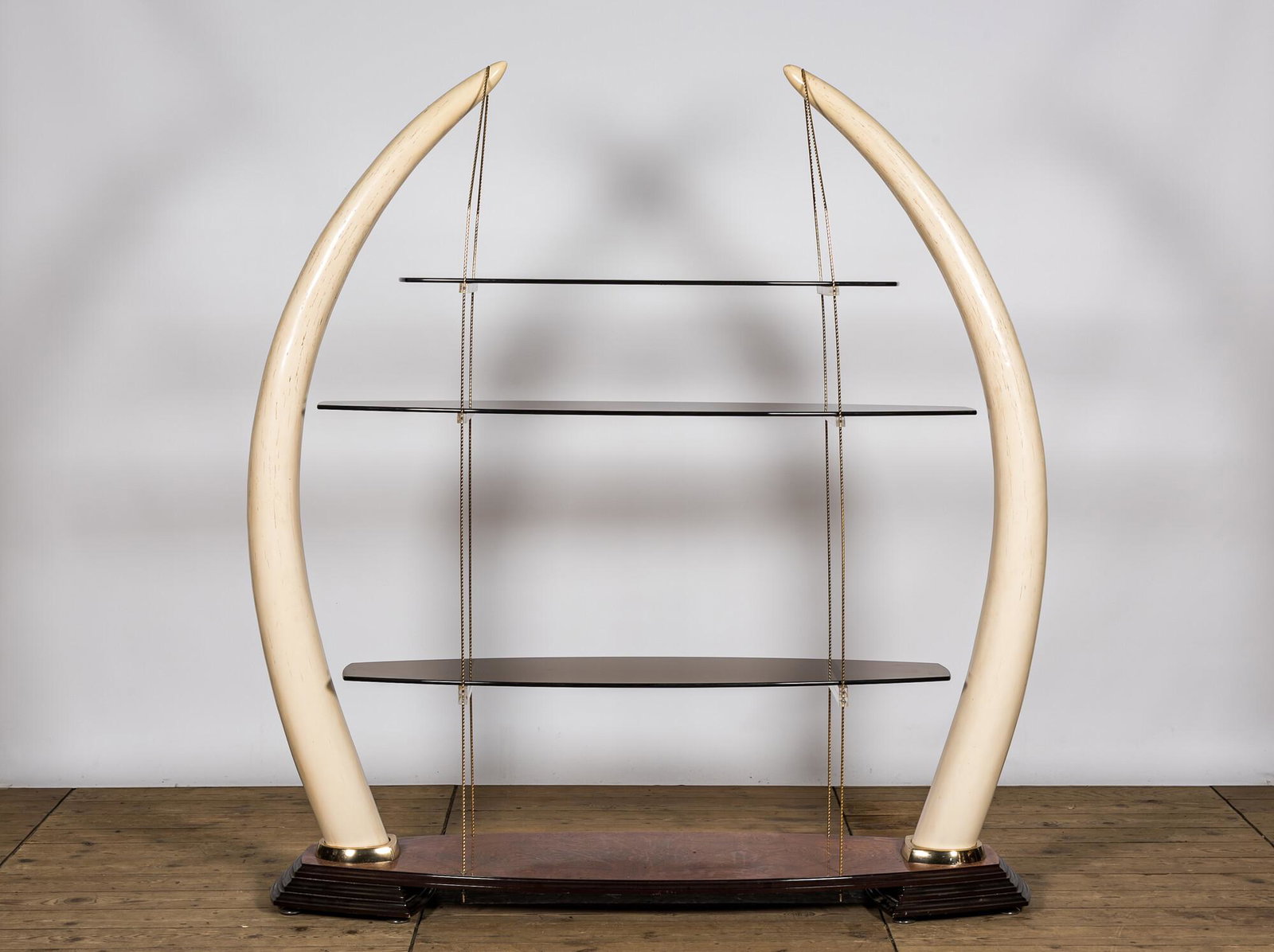A large Ã©tagÃ¨re with glass shelves set in faux ivory tusks, 20th C. (1 of 2)