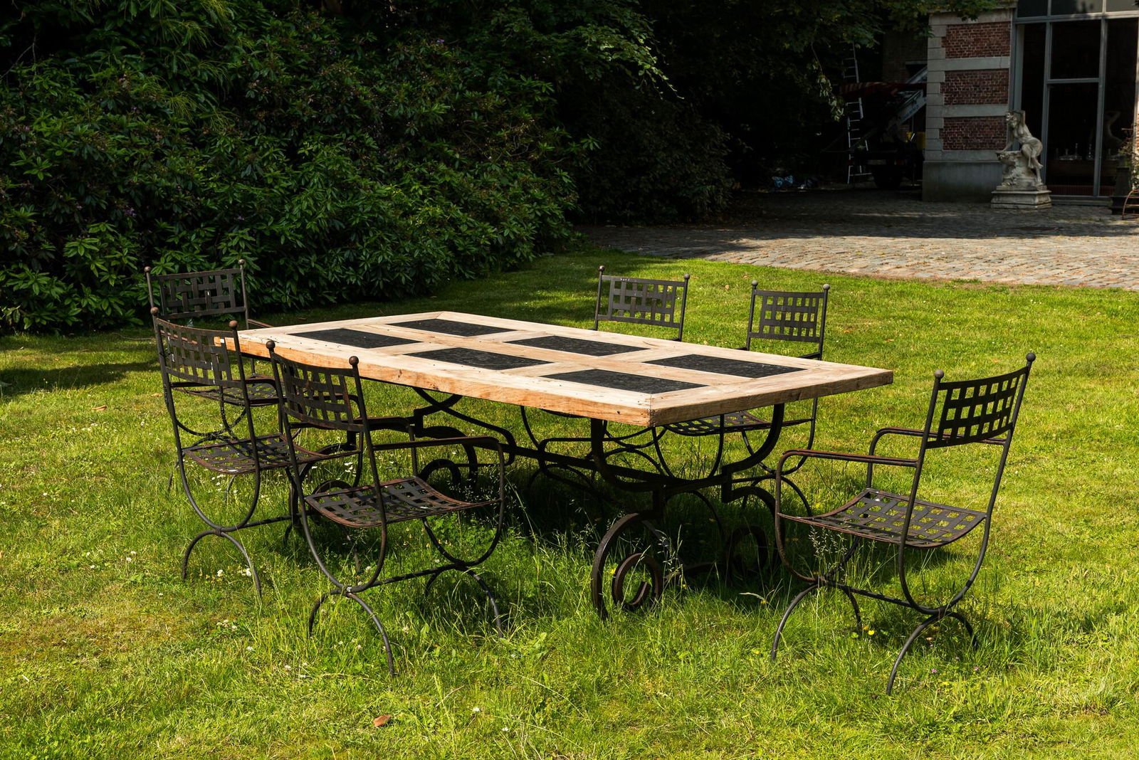 A wrought iron table with slate and wooden top with six chairs, 20th C. (1 of 7)