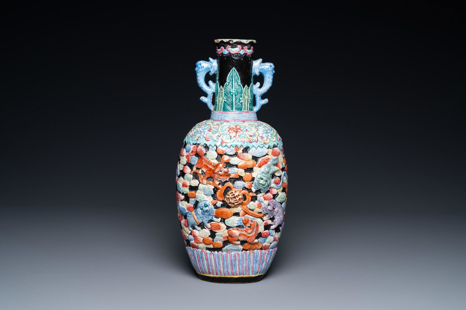 A Chinese famille rose vase with molded design of Buddhist lions, Qianlong mark, 19th C.: H.: 29,5 cm Condition: (UV-checked) - Excellent with a small baking flaw to the lower part of one handle. 品相：（已用紫外线光检੣