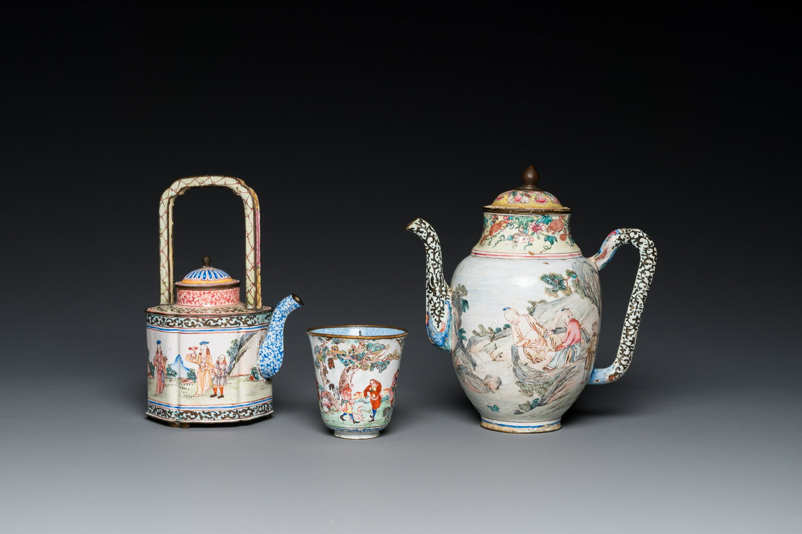 A Chinese Canton enamel teapot, a wine jug and a wine cup, Yongzheng/Qianlong: H.: 17,5 cm - L.: 17 cm (the wine ewer) H.: 17 cm - L.: 11,5 cm (the teapot) H.: 7 cm - Dia.: 6,5 cm (the wine cup)