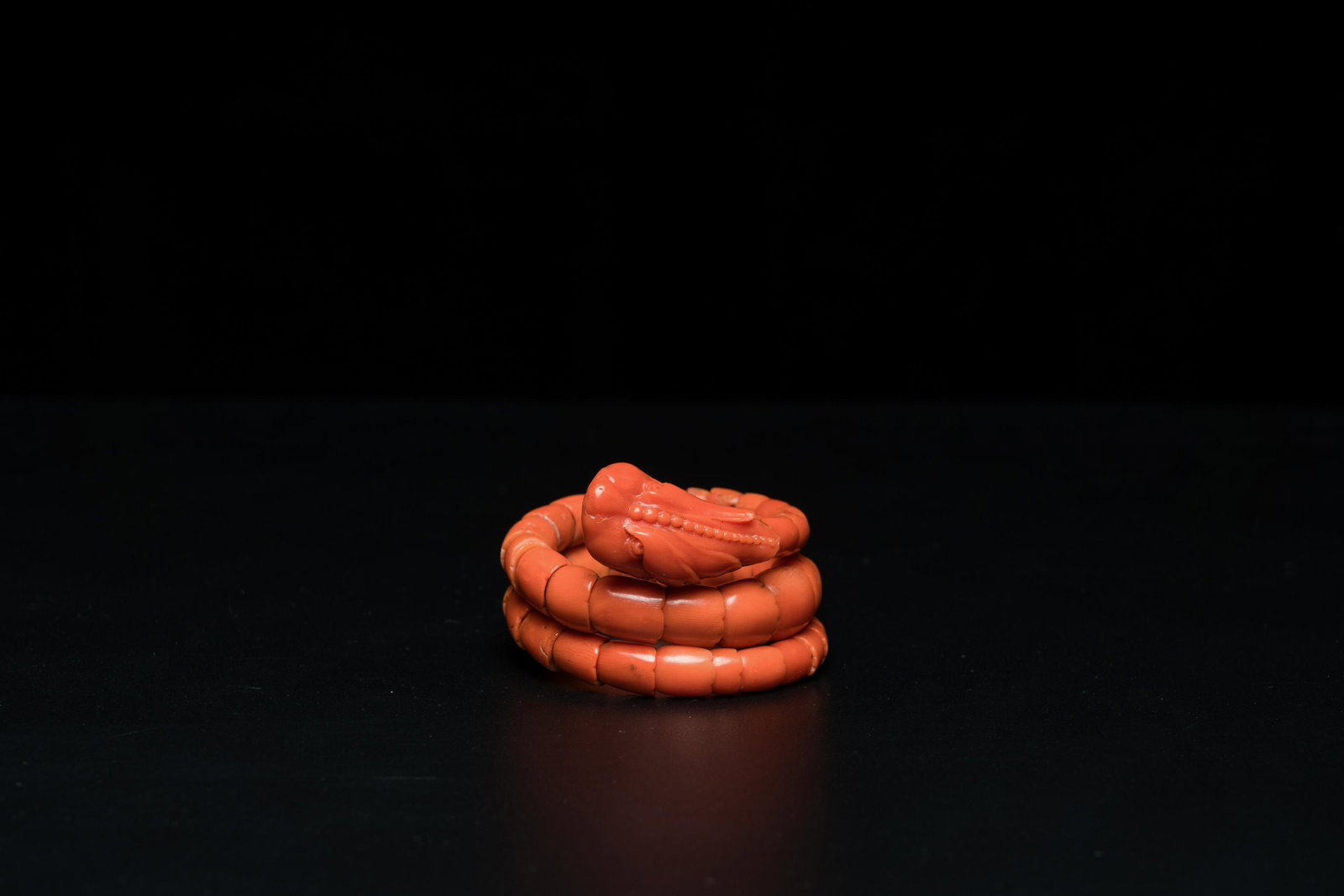 A Chinese red coral bracelet with a dragon's or snake's head, 19th C. (1 of 8)