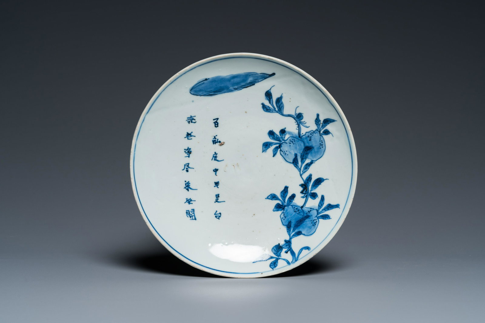 A Chinese blue and white ko-sometsuke 'peach tree and poem' dish for the Japanese market, Chongzhen: Dia.: 20,5 cm Condition: (UV-checked) - In quasi excellent condition with a few minor typical superficial chips to the rim. - Some baking flaws throughout. 品相報告：A