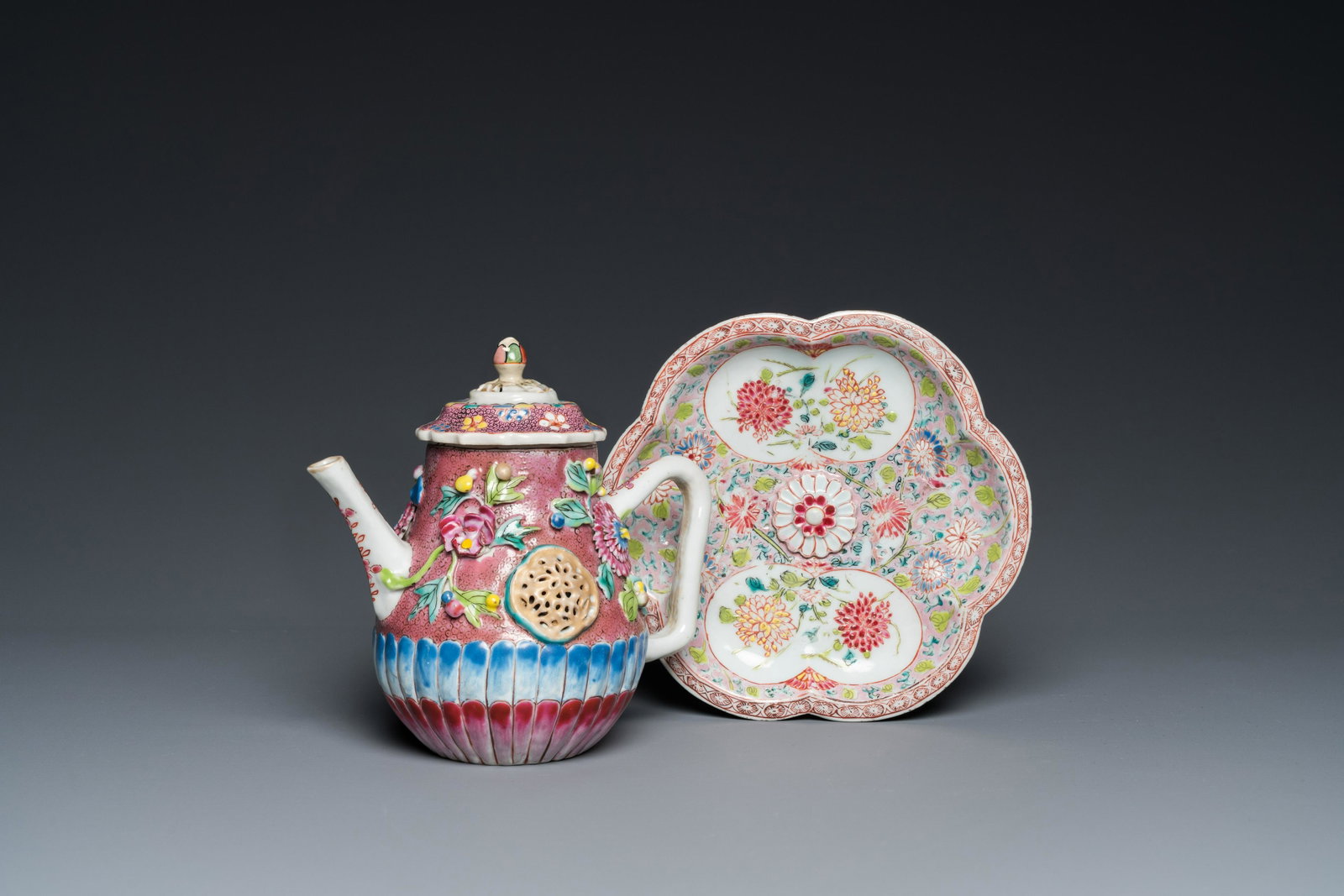 A Chinese famille rose relief-decorated teapot and cover on stand, Yongzheng: L.: 15 cm - H.: 14 cm (the teapot) Dia.: 15,5 cm (the stand)