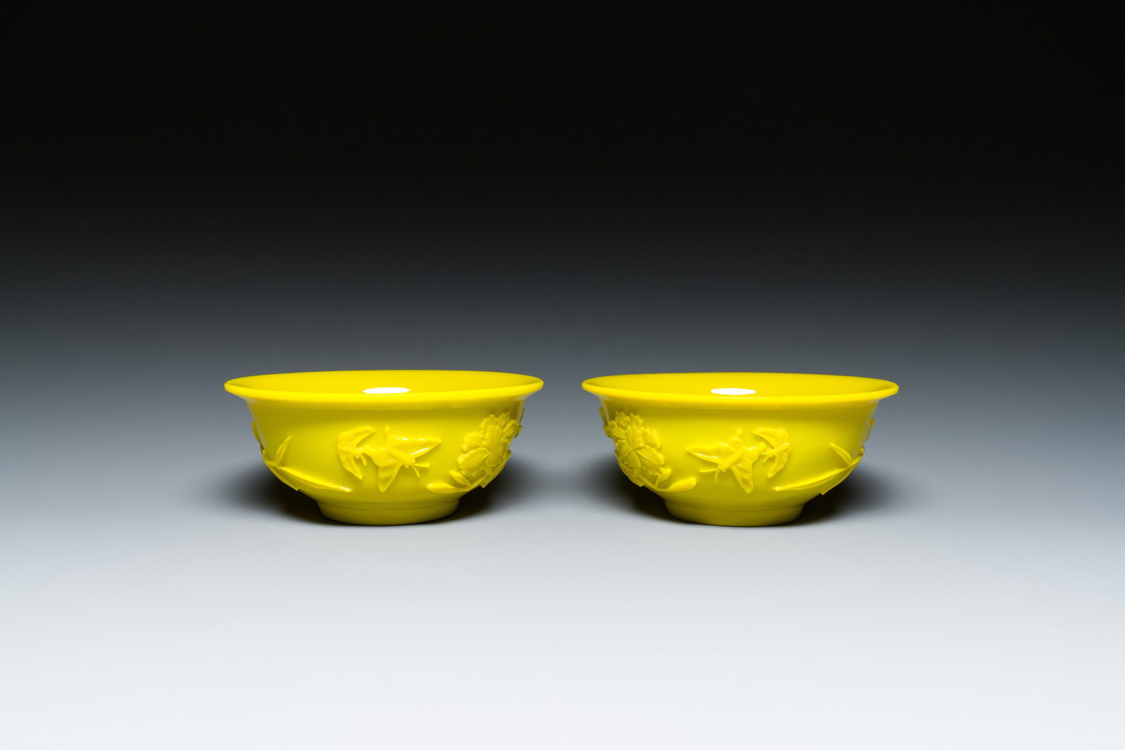 A pair of Chinese yellow Beijing glass bowls with floral design, 19/20th C.: Full title: A pair of Chinese yellow Beijing glass bowls with floral design, 19/20th C. Description: Dia.: 15,5 cm - H.: 6,5 cm Provenance: - The collection of a Belgian connoisseur.