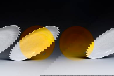 A pair of Chinese monochrome yellow-glazed saucers with incised designs of pine and cranes