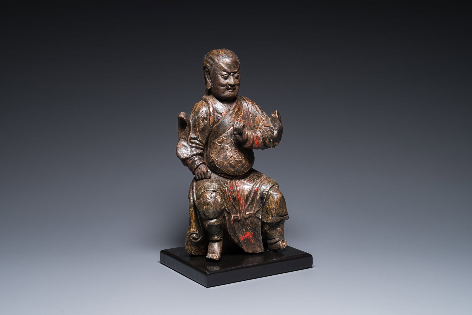 A Chinese lacquered and polychromed wood sculpture of a Buddhist guardian, Ming: A Chinese lacquered and polychromed wood sculpture of a Buddhist guardian, Ming H.: 42,5 cm (incl. stand) H.: 39,5 cm (the figure) Provenance: - The collection of Mr. and Mrs. S., Ghent, Belgium. - Ac