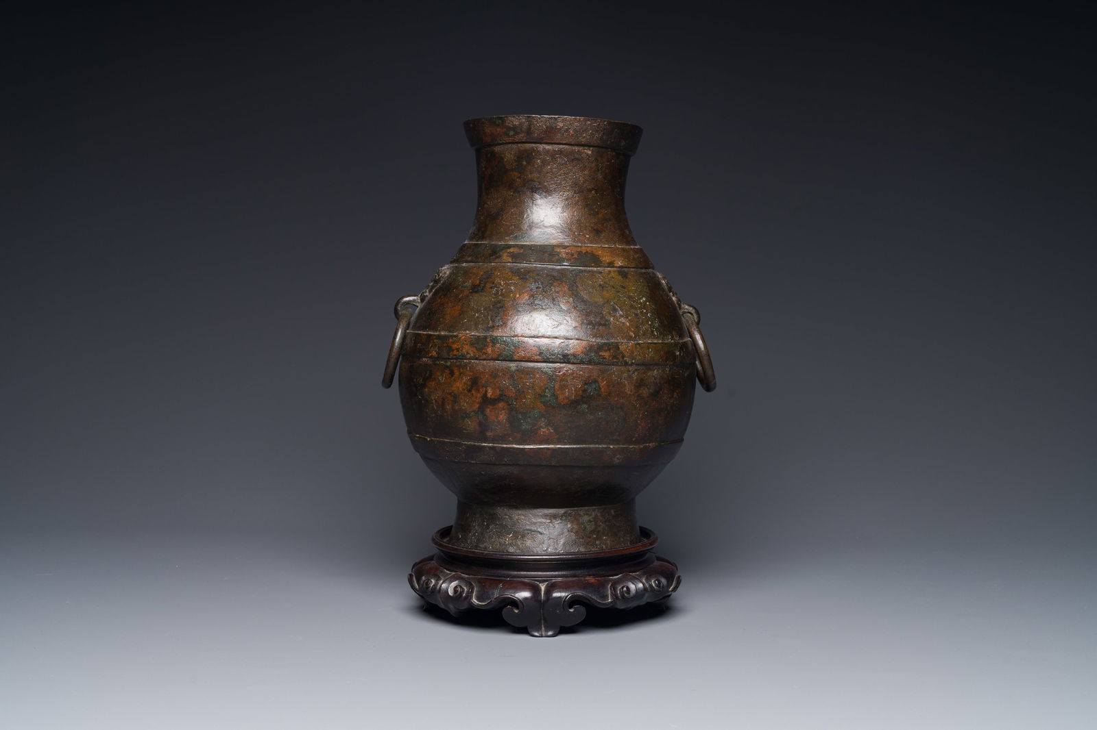 A Chinese bronze 'hu' vase with Han-style taotie handles on wooden base, Ming (1 of 4)