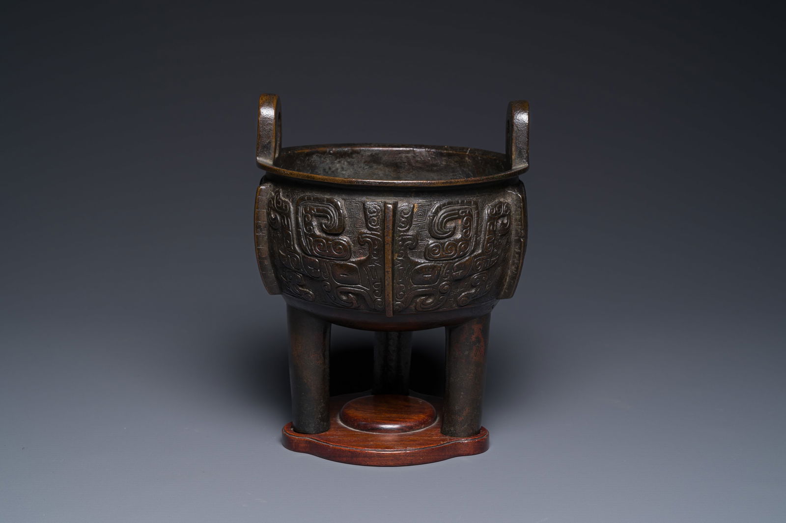 A Chinese archaistic bronze tripod censer on wooden stand, 'ding', Song/Ming (1 of 7)
