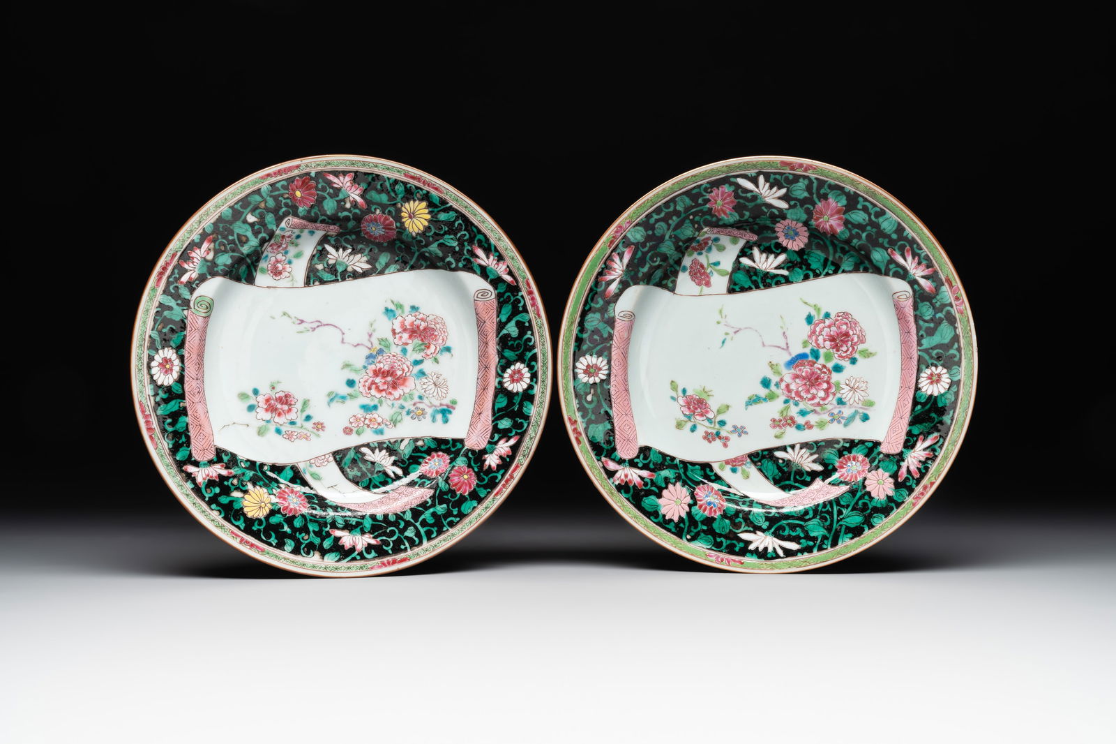 A pair of Chinese famille rose black-ground 'flowers and scrolls' plates, Yongzheng/Qianlong (1 of 2)