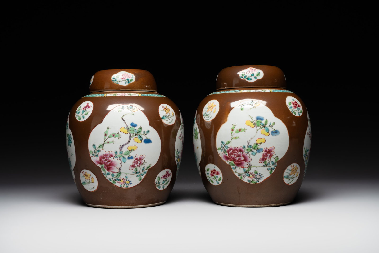 A pair of Chinese capucin-brown-ground famille rose covered jars with floral design, Yongzheng/Qianl: A pair of Chinese capucin-brown-ground famille rose covered jars with floral design, Yongzheng/Qianlong H.: 23,5 cm (incl. cover)