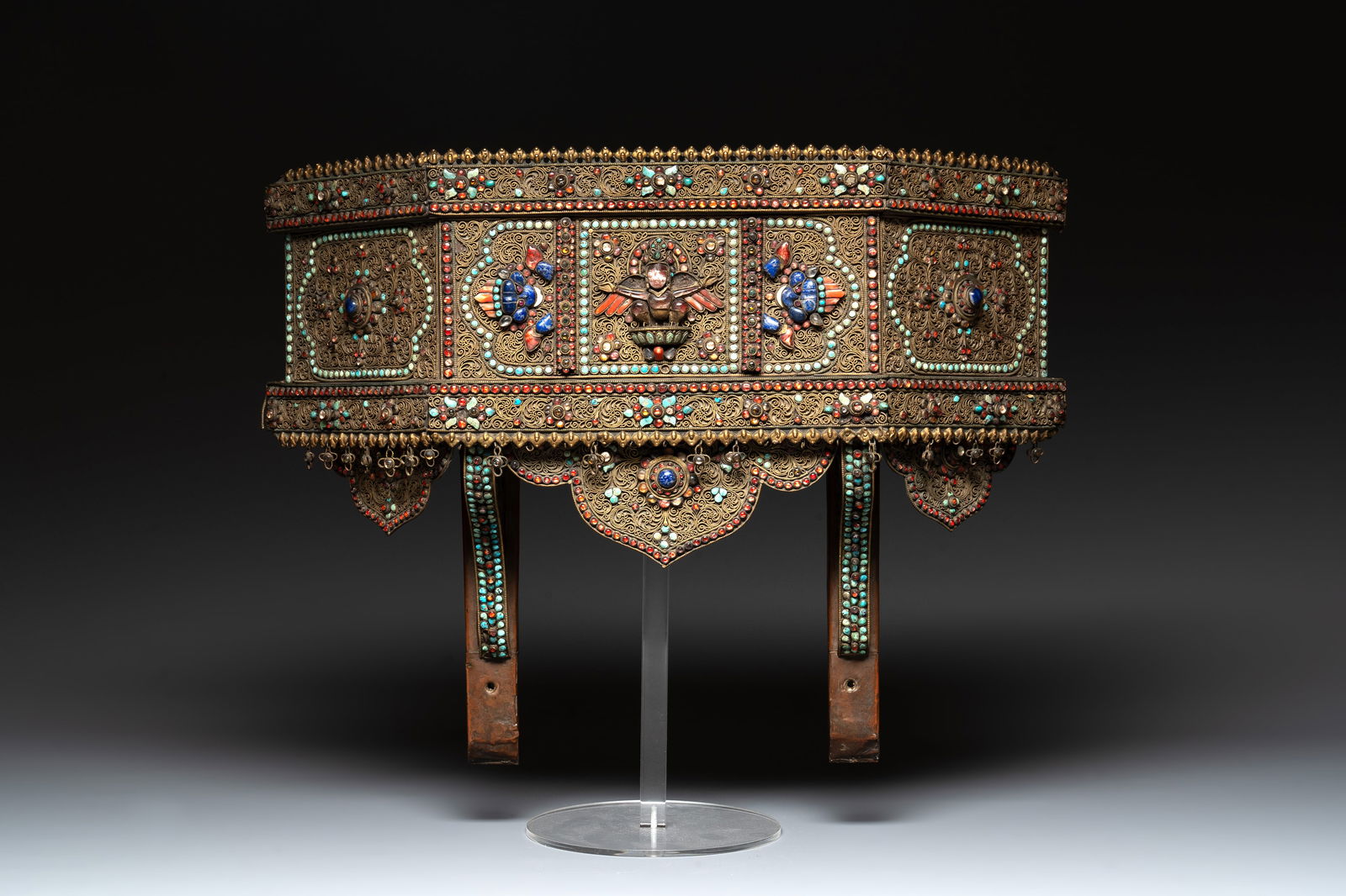 A Nepalese gilt copper console inlaid with glass, precious stones and red coral, 19th C.: A Nepalese gilt copper console inlaid with glass, precious stones and red coral, 19th C. Dim.: 47 x 12,5 x 35 cm