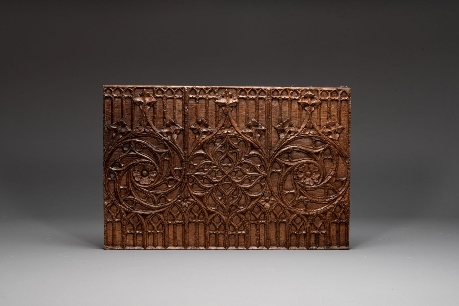 A Gothic carved oak front panel of a chest with arcades and rosettes, France, late 15th C. (1 of 2)