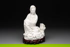 A Chinese Dehua blanc de Chine figure of a seated Guanyin on wooden stand, 19/20th C.