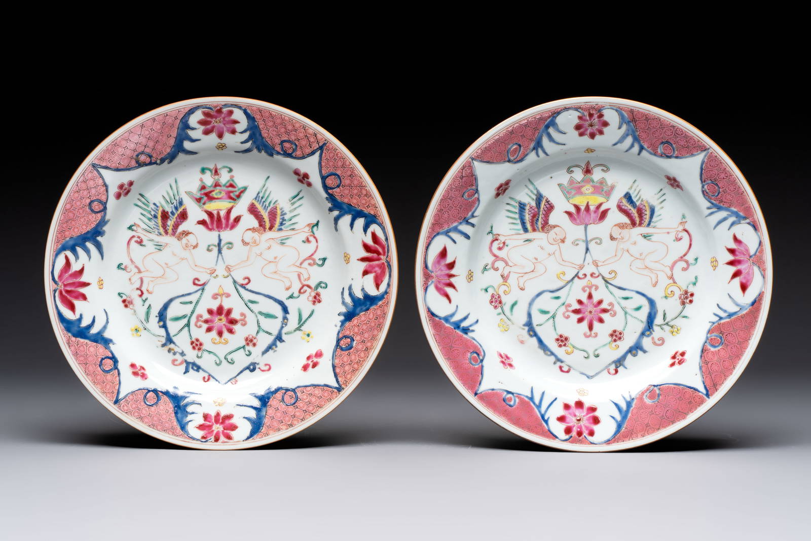A pair of Chinese famille rose 'winged putti' plates, Yongzheng/Qianlong