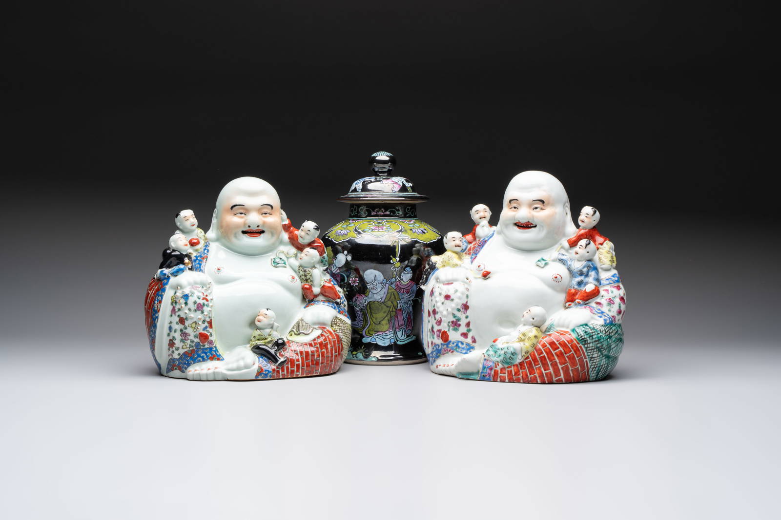 Two Chinese famille rose Milefo Buddhas and a famille rose black-ground covered vase, Zhu Mao Ji and