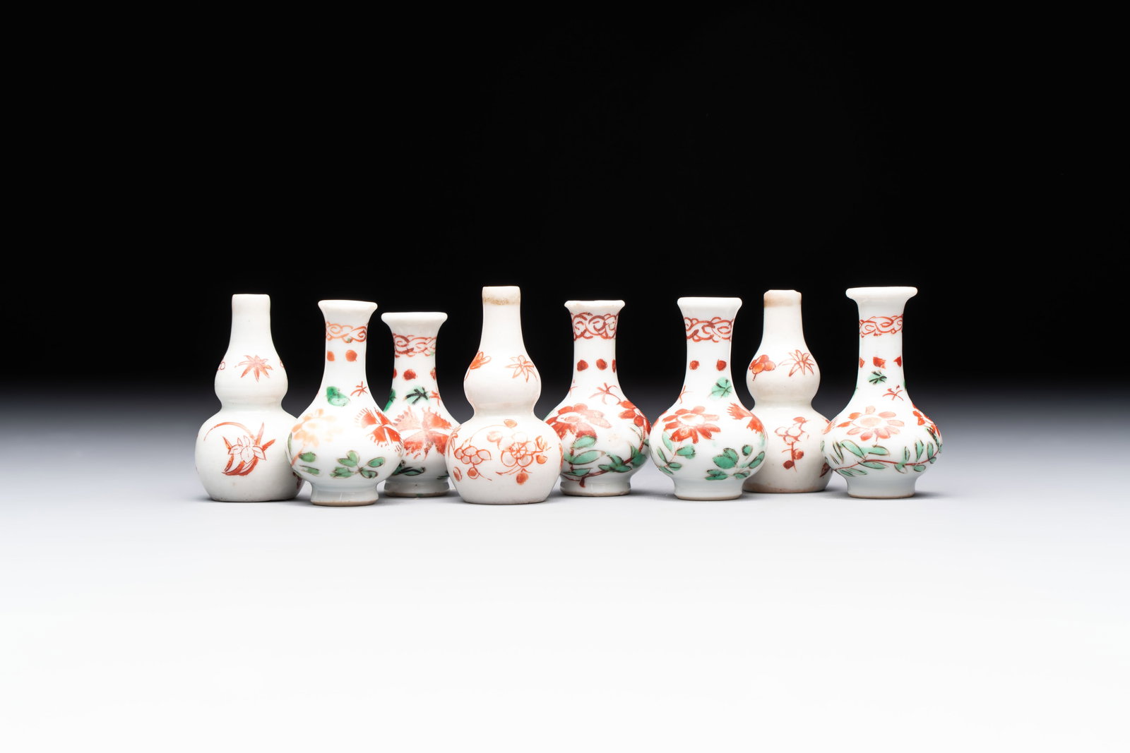 Eight Chinese wucai and gilt-iron-red miniature vases with floral design, Kangxi: Eight Chinese wucai and gilt-iron-red miniature vases with floral design, Kangxi H.: 4,6 cm (the tallest) H.: 4,4 cm (the smallest) Provenance: A private Dutch collection.