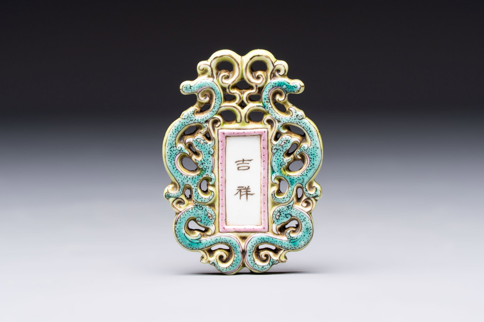 A Chinese famille rose 'Ji Xiang Ru Yi' reticulated pendant, 19/20th C.: A Chinese famille rose 'Ji Xiang Ru Yi' reticulated pendant, 19/20th C. Dim.: 6,8 x 4,8 x 1 cm