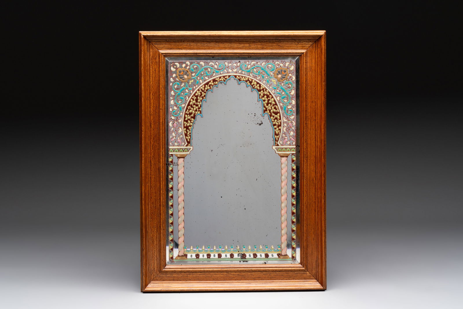 An enamelled glass Orientalist-style mirror in a wooden frame, in the style of A. J. & L. Lobmeyr, (1 of 2)