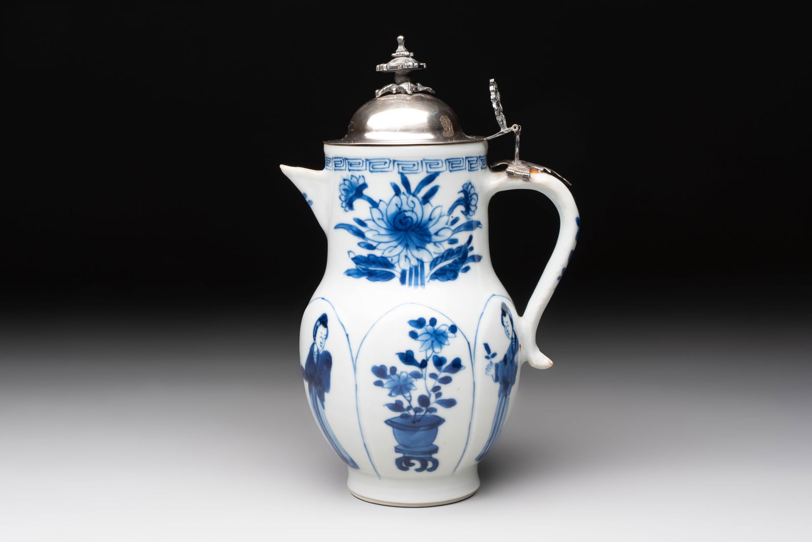 A Chinese blue and white 'Long Eliza' jug with a silver-mounted lid, Kangxi: A Chinese blue and white 'Long Eliza' jug with a silver-mounted lid, Kangxi L.: 13 cm - H.: 19 cm (incl. silver mount)