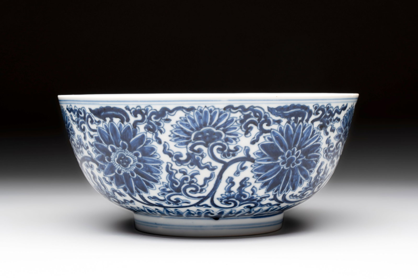 A Chinese blue and white 'lotus scroll' bowl, Xuande mark, Kangxi: A Chinese blue and white 'lotus scroll' bowl, Xuande mark, Kangxi Dia.: 19,7 cm - H.: 8,8 cm