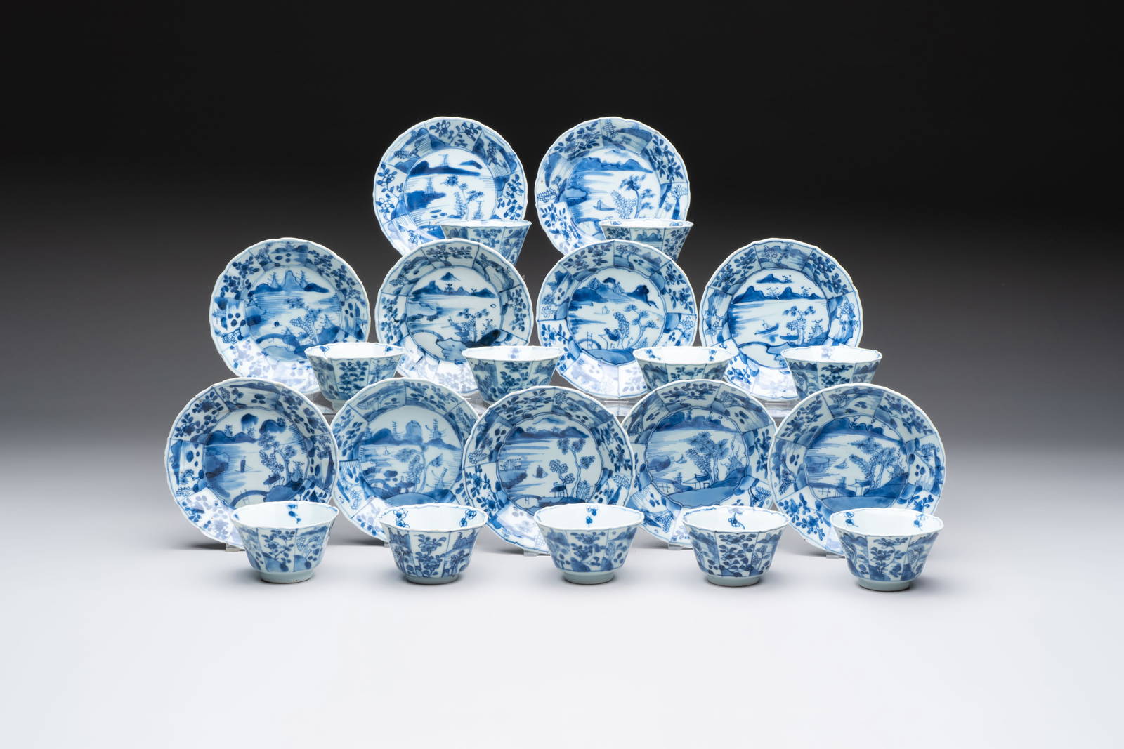 A set of 11 Chinese blue and white cups and saucers with riverscape design, Kangxi