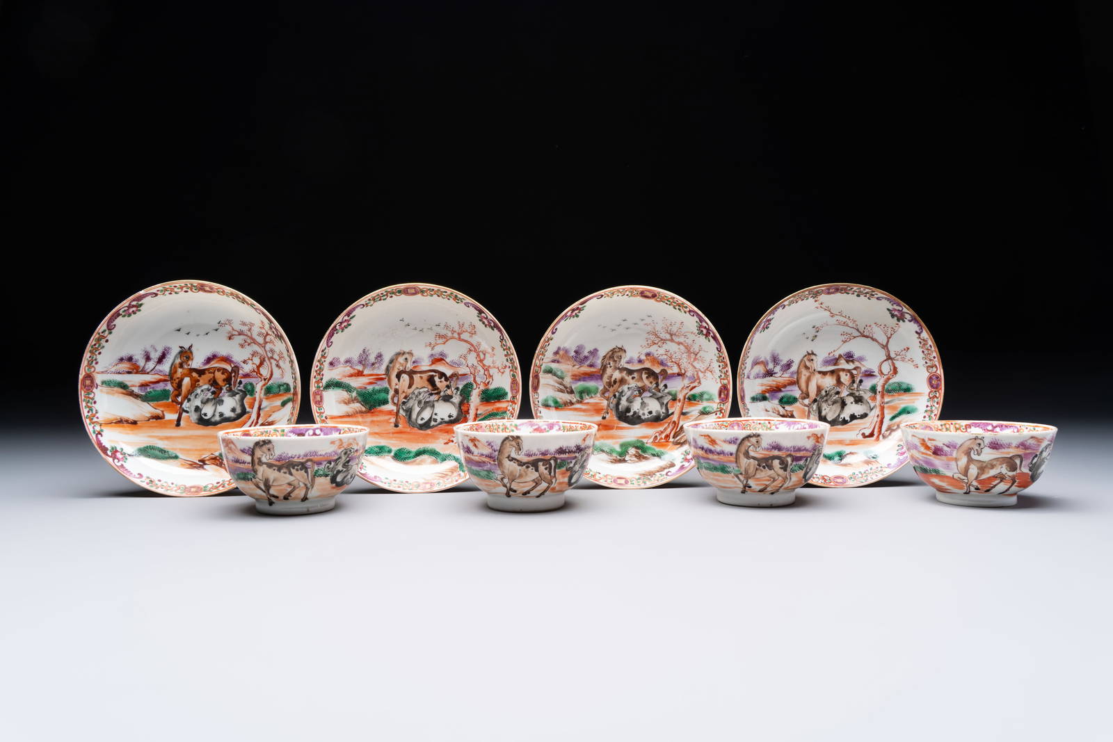 A set of four Chinese famille rose cups and saucers with horses, Qianlong