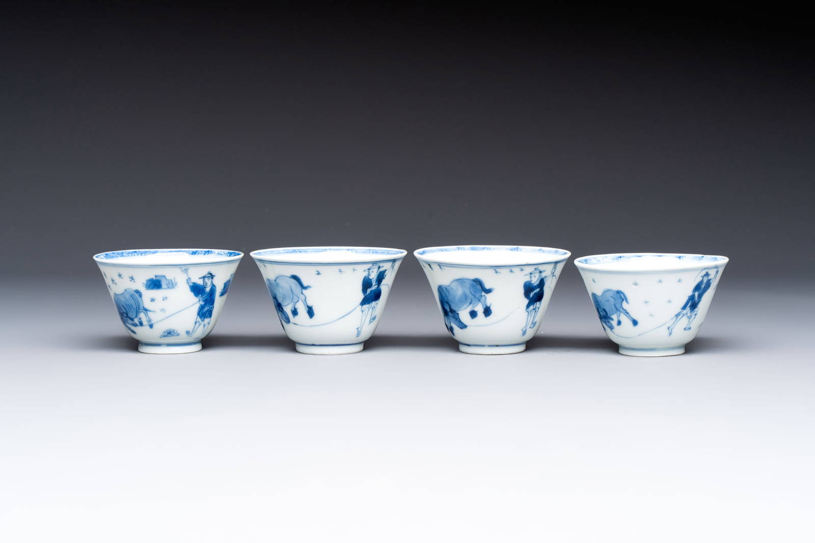 Four Chinese blue and white 'boy and buffalo' cups, Qi Yue Ru Yu and Kun Chi Yu Shi marks, Yongzheng