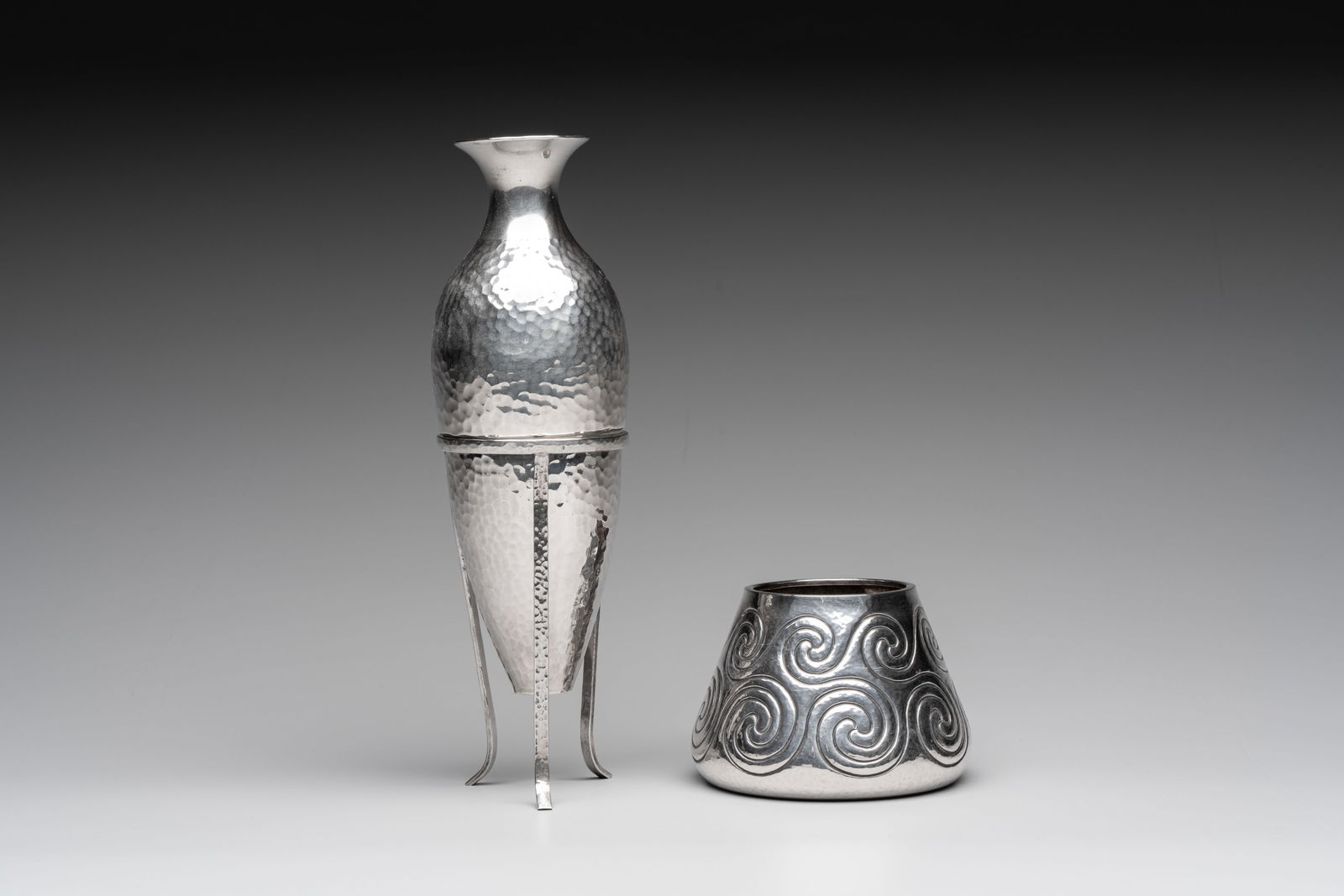 A silver amphora on stand and a Lalaounis silver vase, 925/000, Greece, 20th C.: A silver amphora on stand and a Lalaounis silver vase, 925/000, Greece, 20th C. H.: 23,8 cm (the vase on stand) H.: 7,3 cm (the vase) Weight: - 233 grams (the vase on stand) - 174 grams (the vase)