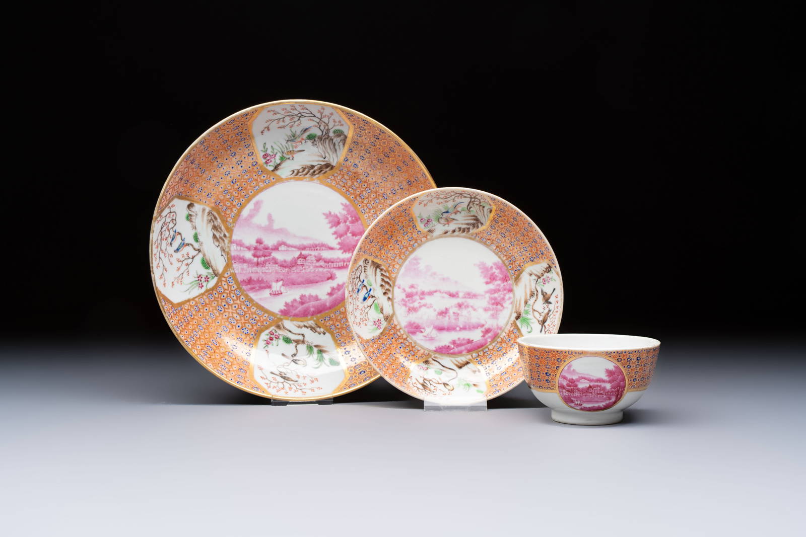 A Chinese famille rose puce-enamelled 'Riverscape' plate, cup and saucer, Jiaqing