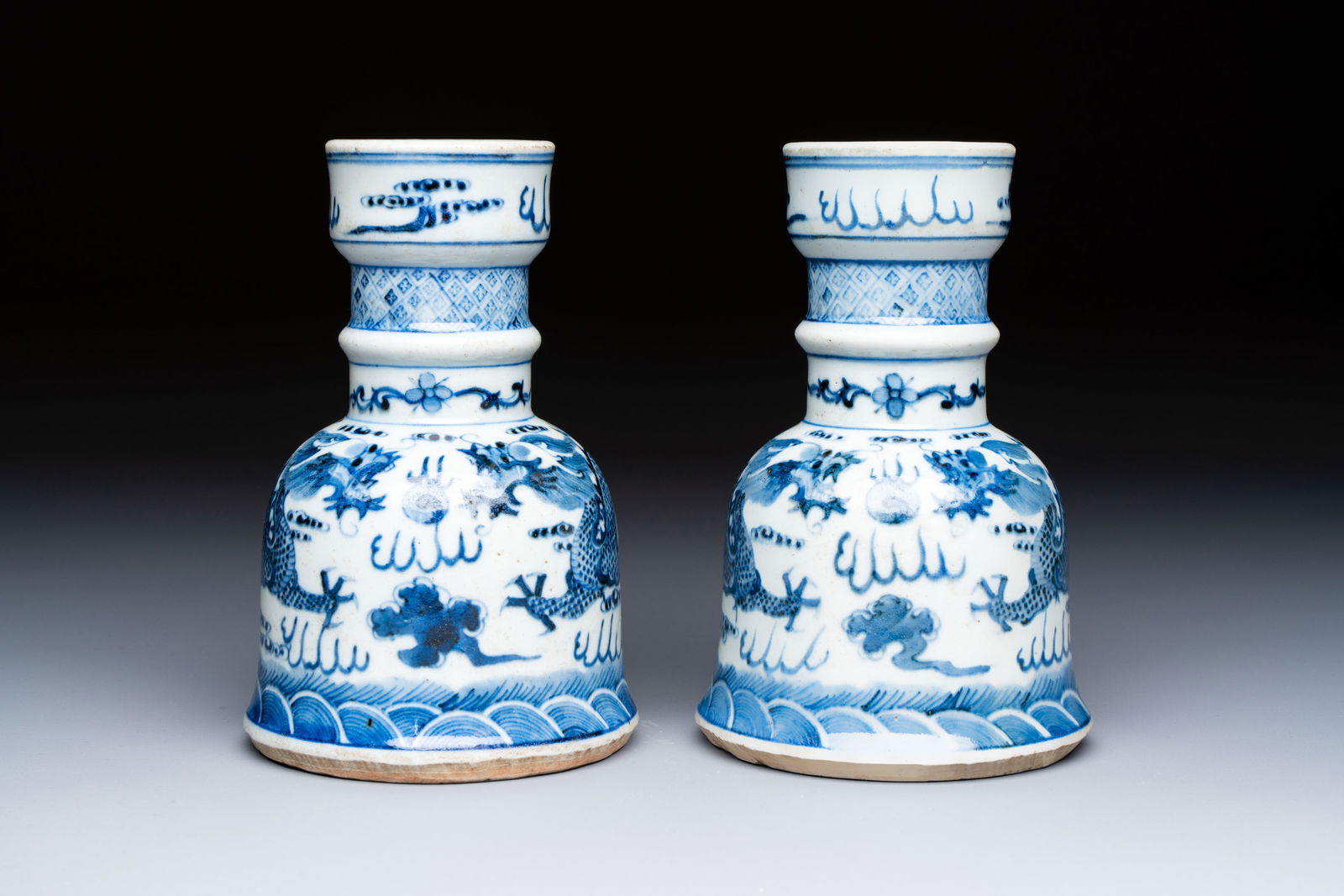 A pair of Chinese blue and white 'Dragons Chasing the Flaming Pearl’ candlesticks, 19th C.: A pair of Chinese blue and white 'Dragons Chasing the Flaming Pearl’ candlesticks, 19th C. H.: 15,1 cm