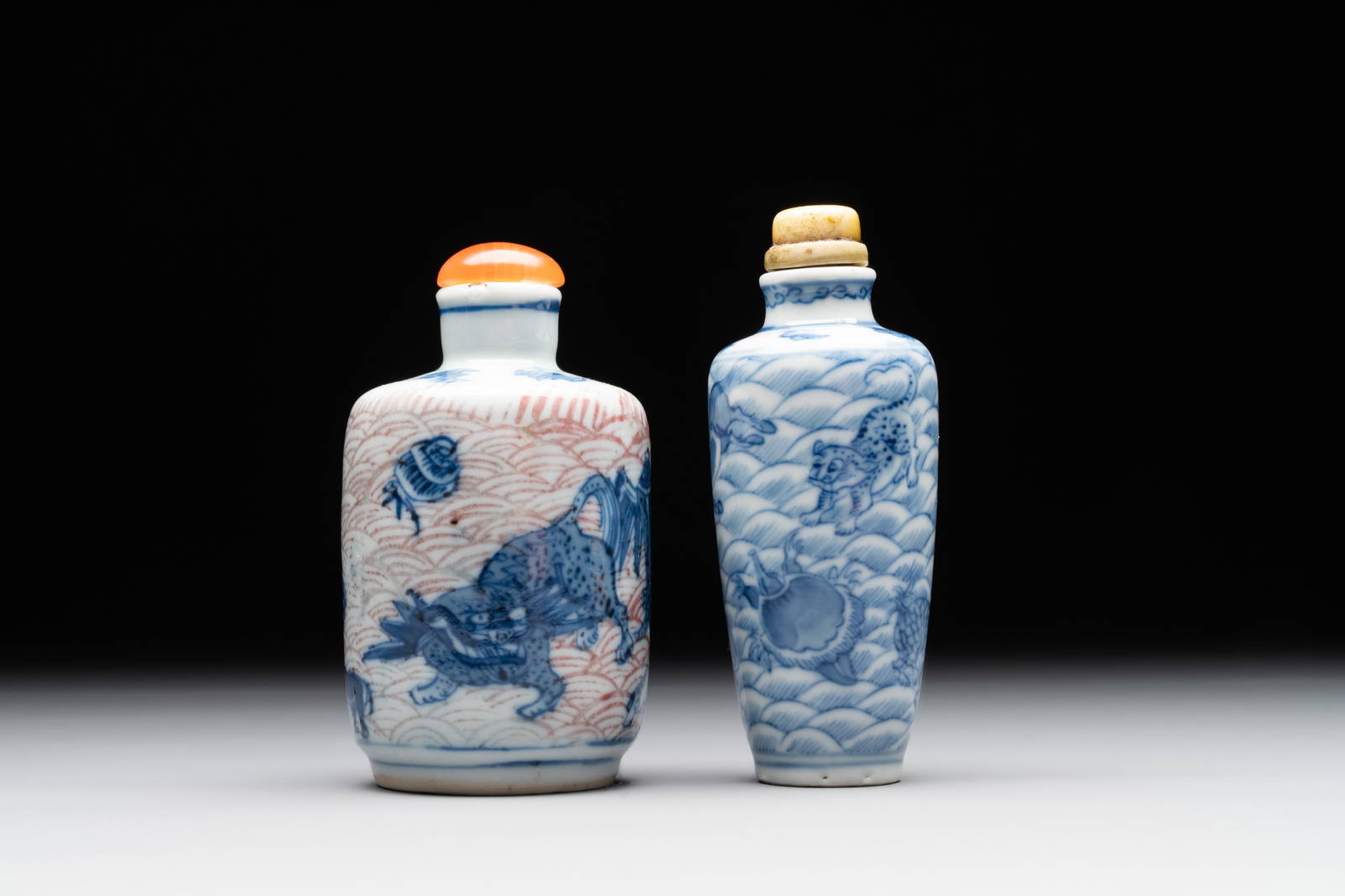Two Chinese blue, white and copper-red 'Mythical Animals' snuff bottles, Qianlong mark and of the