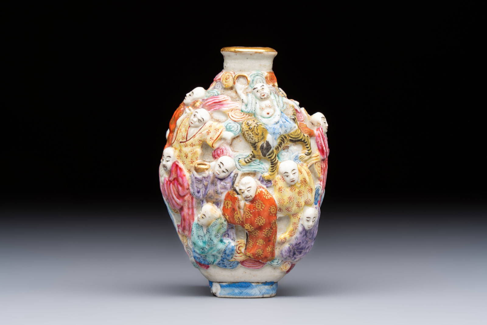 A Chinese famille rose moulded '18 Luohan' snuff bottle, Qianlong mark, 19th C.