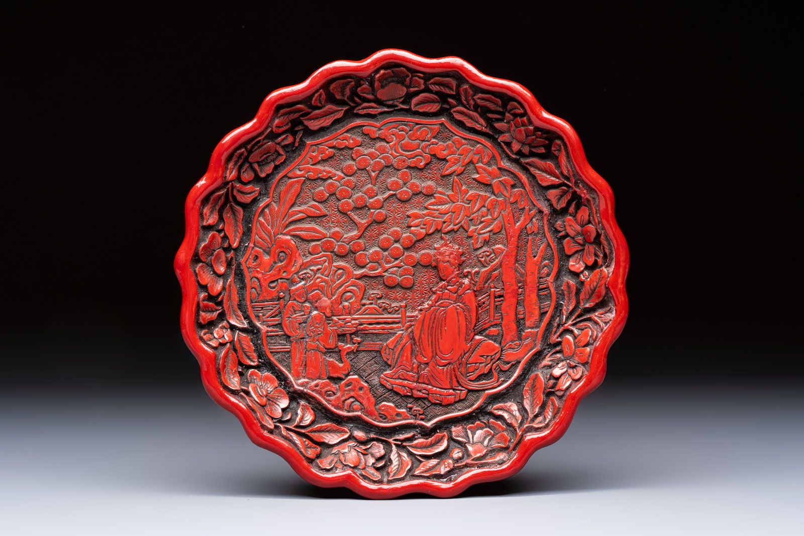 A fine Chinese red cinnabar lacquer flower-shaped 'Xi Wang Mu' dish, Ming: A fine Chinese red cinnabar lacquer flower-shaped 'Xi Wang Mu' dish, Ming Dia.: 18 cm